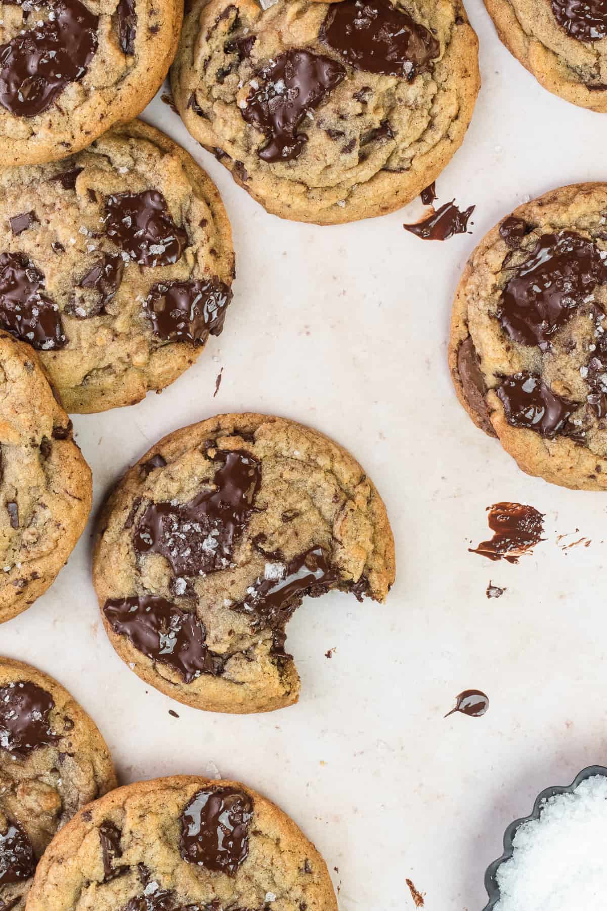 A pile of Nutella Chocolate Chip Cookies with one cookie missing a bite out of it.