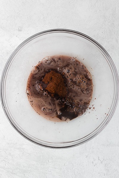 Hot water, cocoa powder and espresso powder in a bowl.
