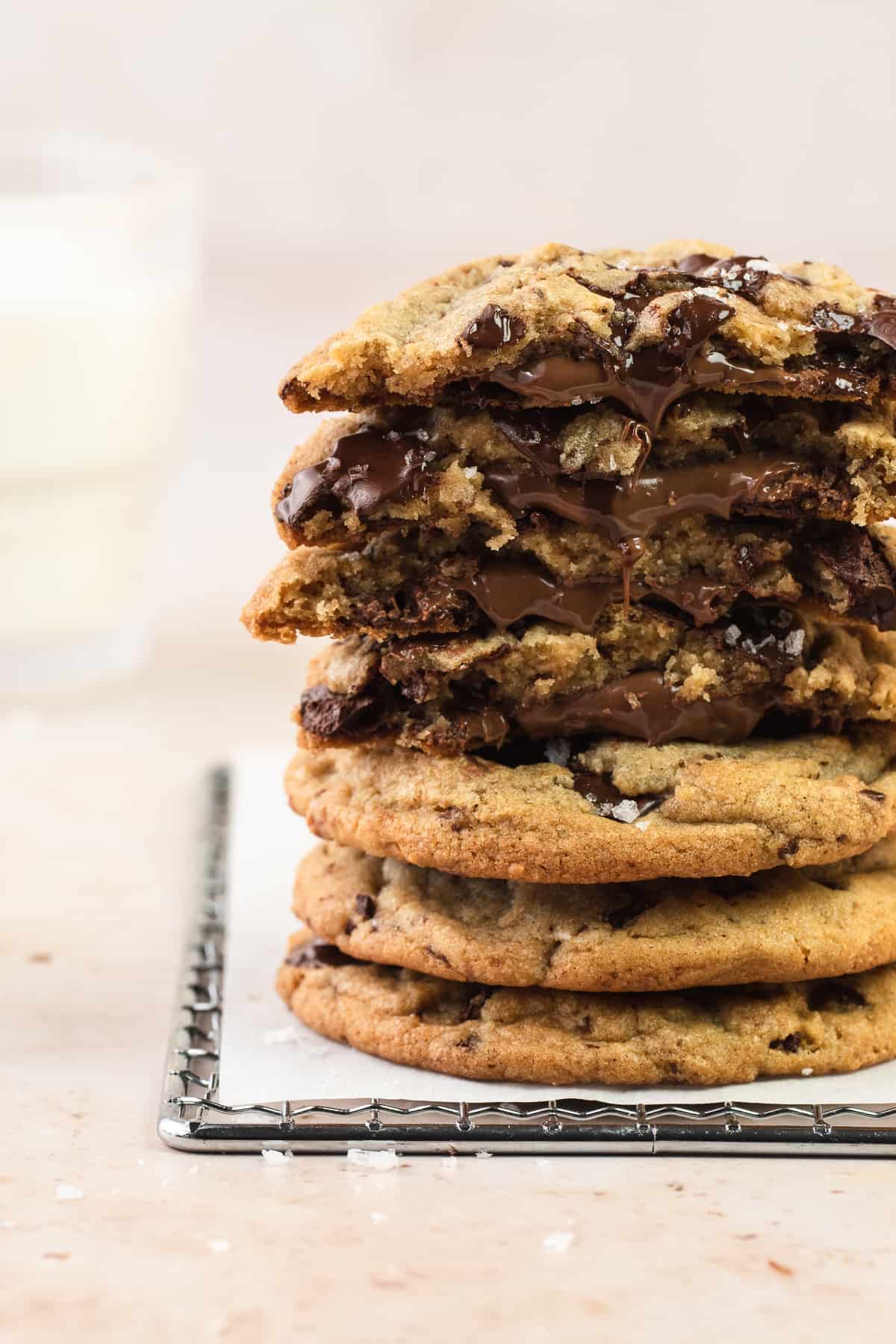 A stack of Nutella Chocolate Chip Cookies and glass of milk in the back
