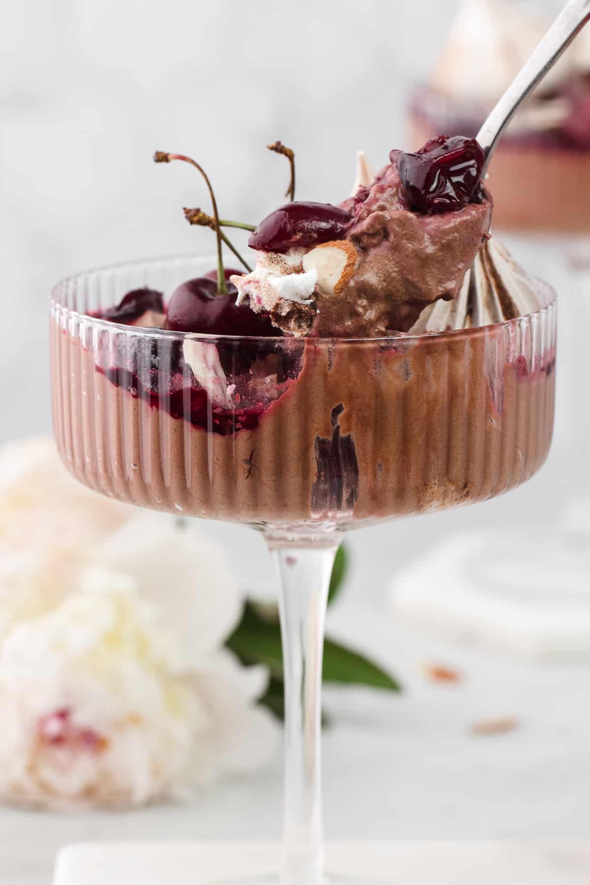 A close up of a glass of Black Forest Eton Mass with a spoon coming out of it