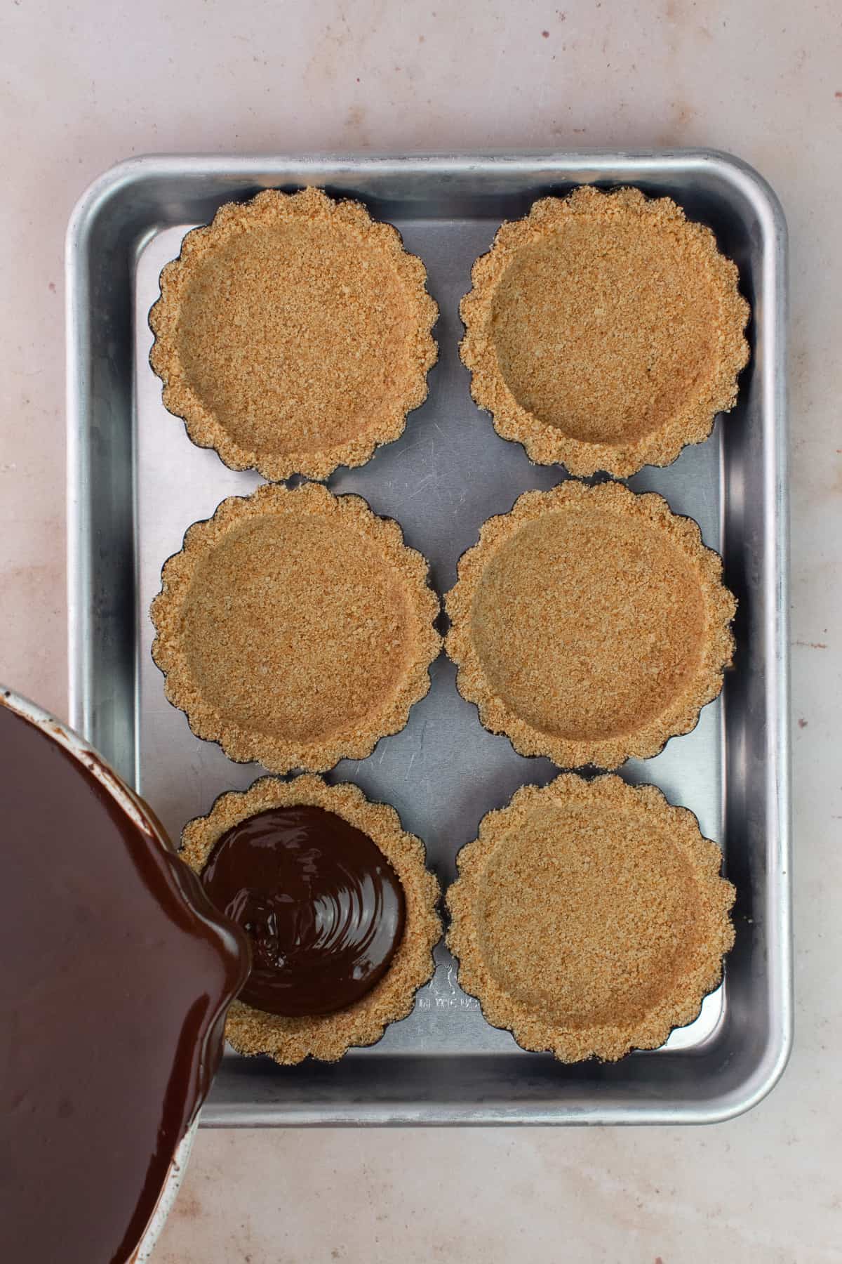 Chocolate filling is poured into mini tart shells