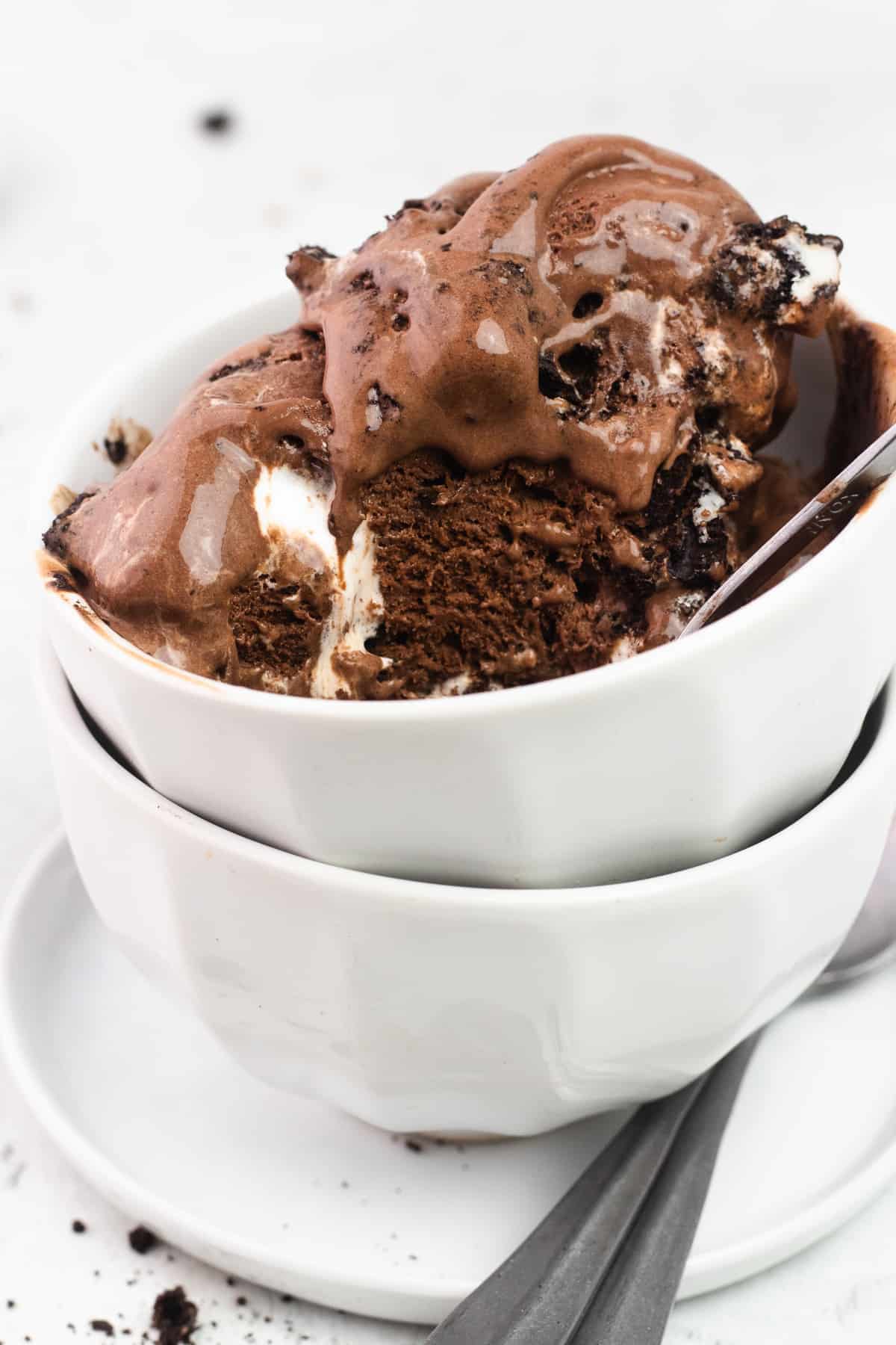 A close up of Chocolate Ice Cream with Oreos and Marshmallow in a bowl with a spoon