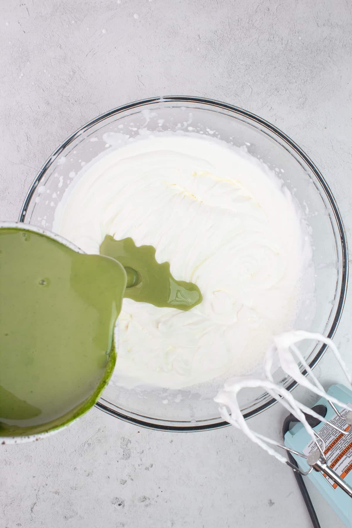 Condensed milk mixture added to large bowl of whipped cream