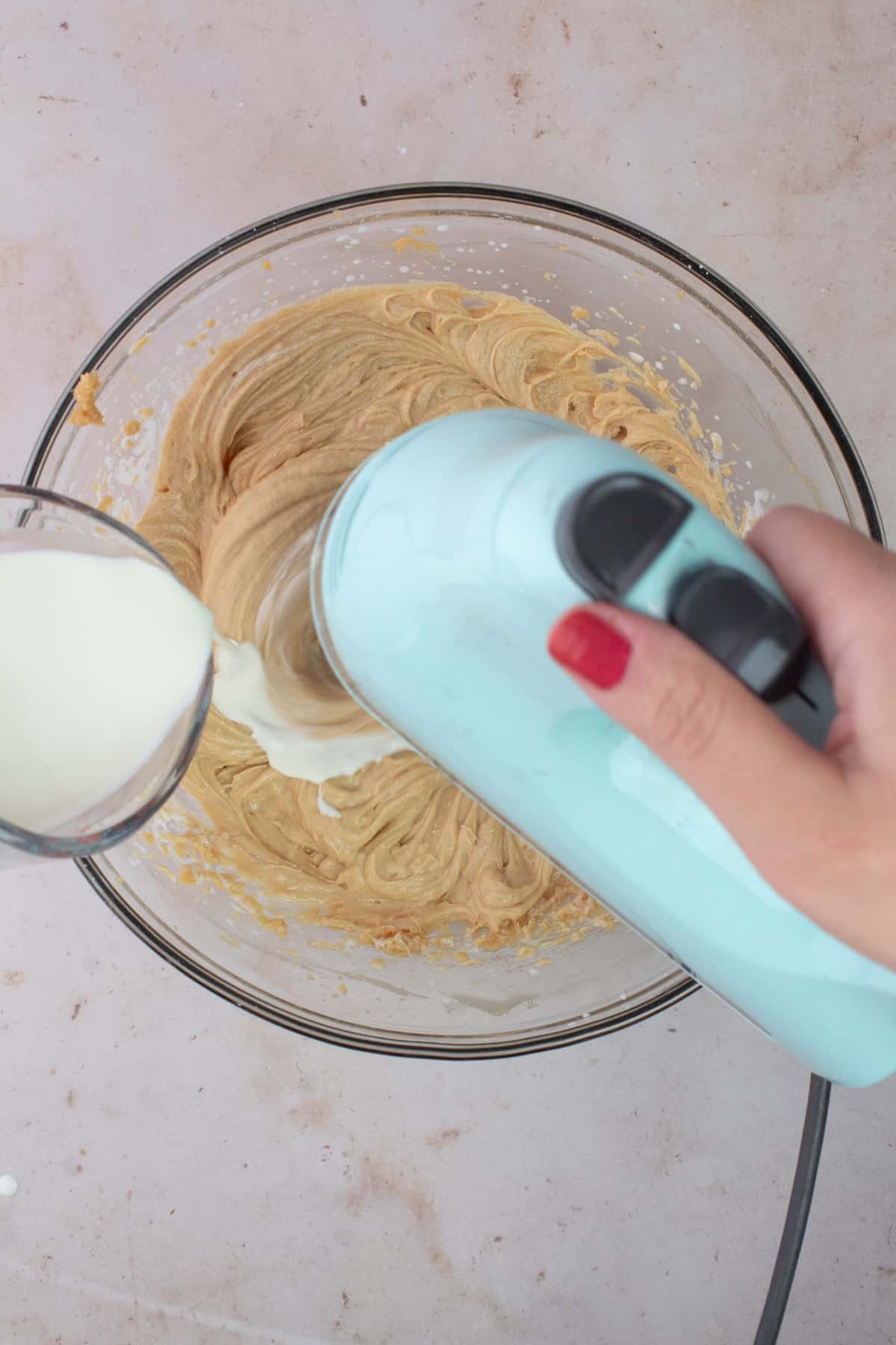 Electric mixer beating heavy cream into peanut butter filling.