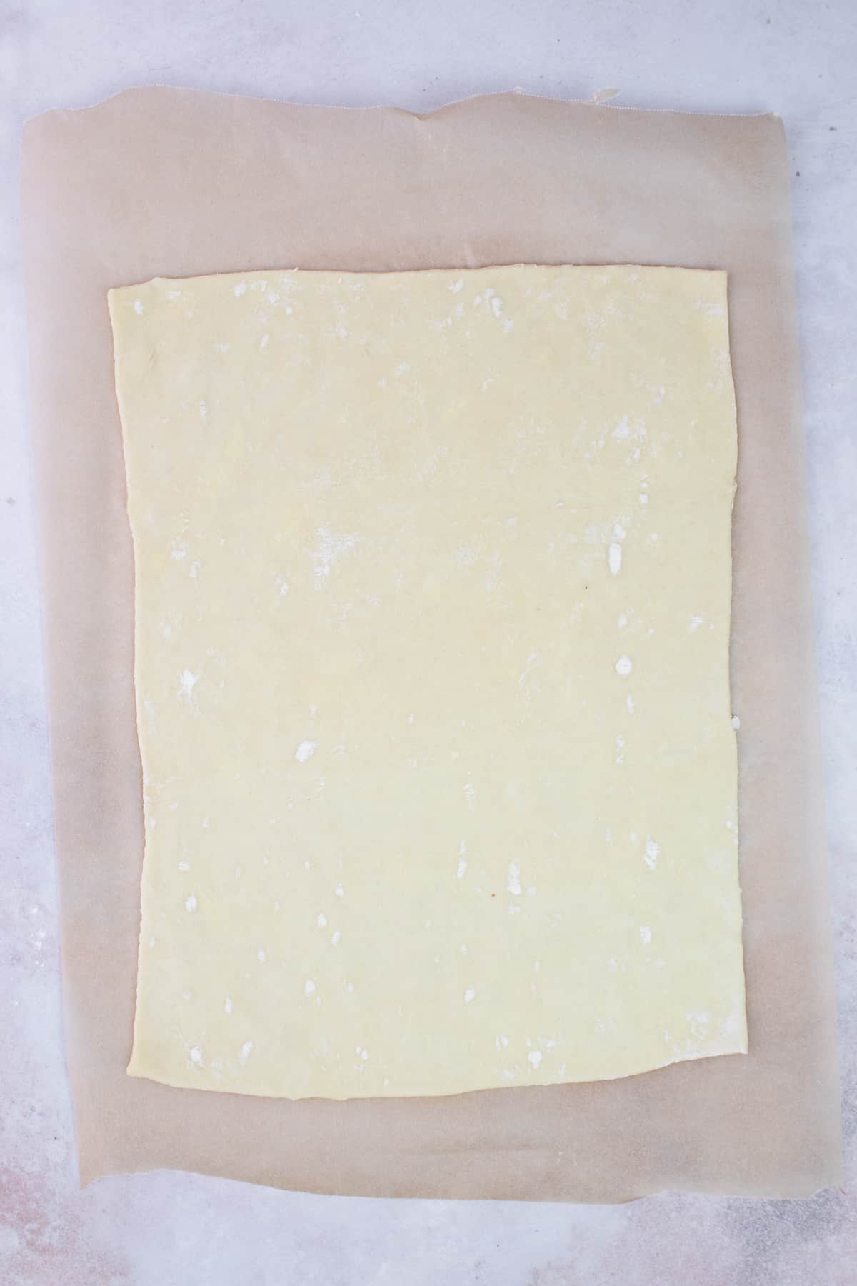 A sheet of puff pastry rolled out on parchment paper