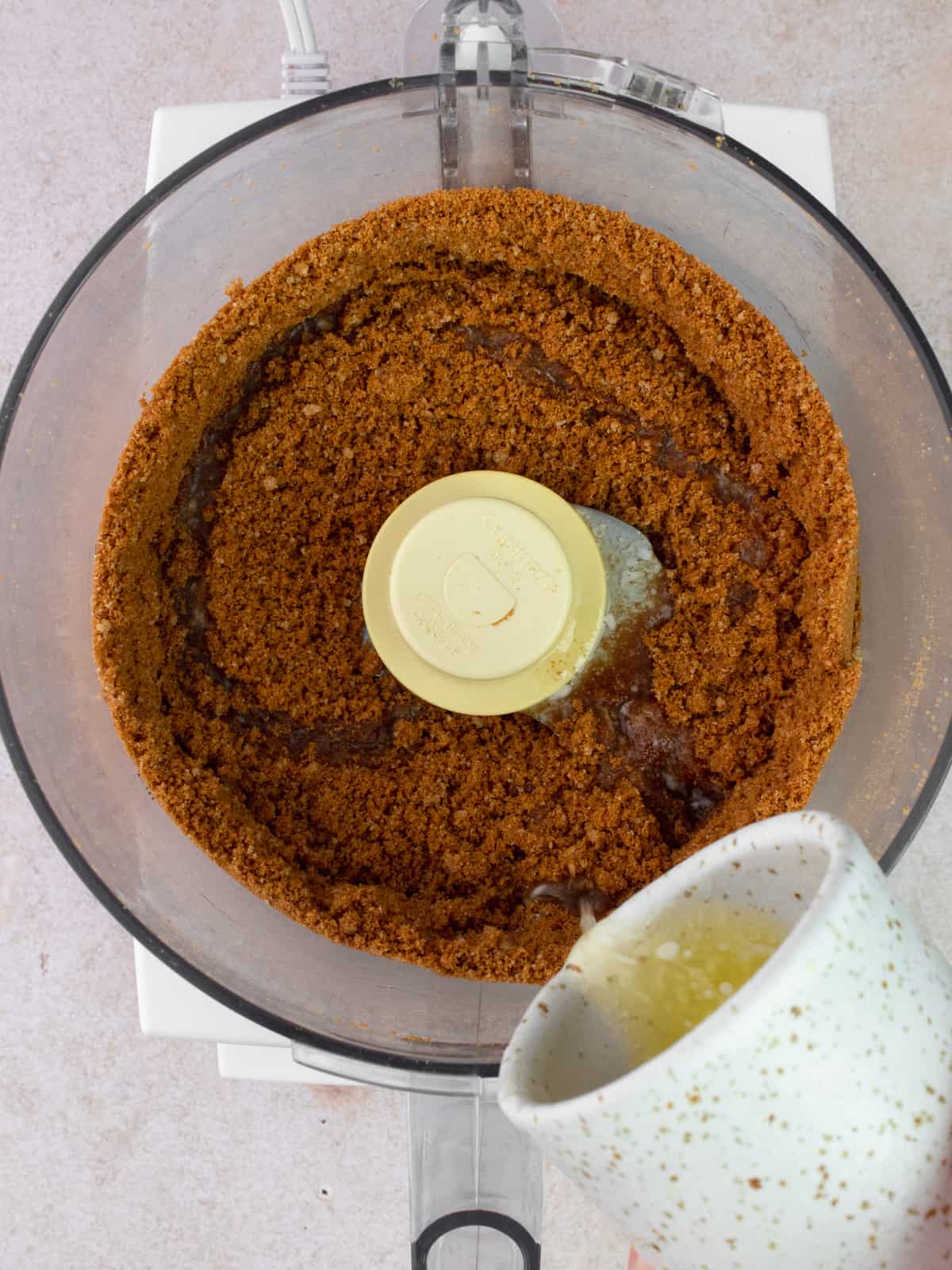 Melted butter is added to Biscoff cookies crumbs