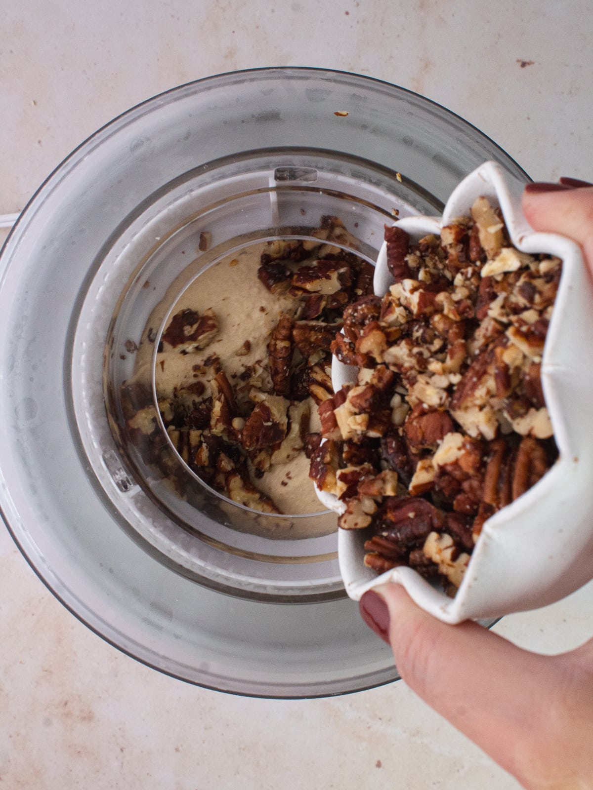 chopped pecans are added to churning ice cream