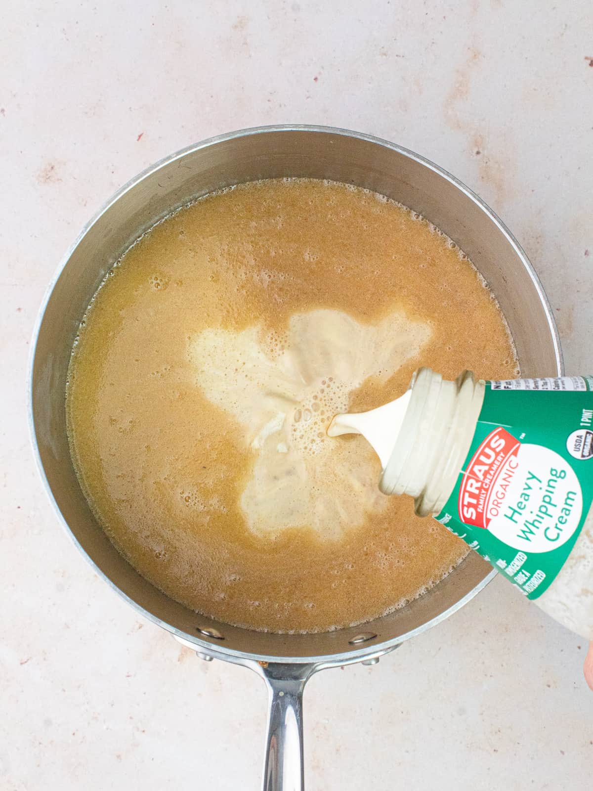 cream being poured in saucepan with butter and brown sugar