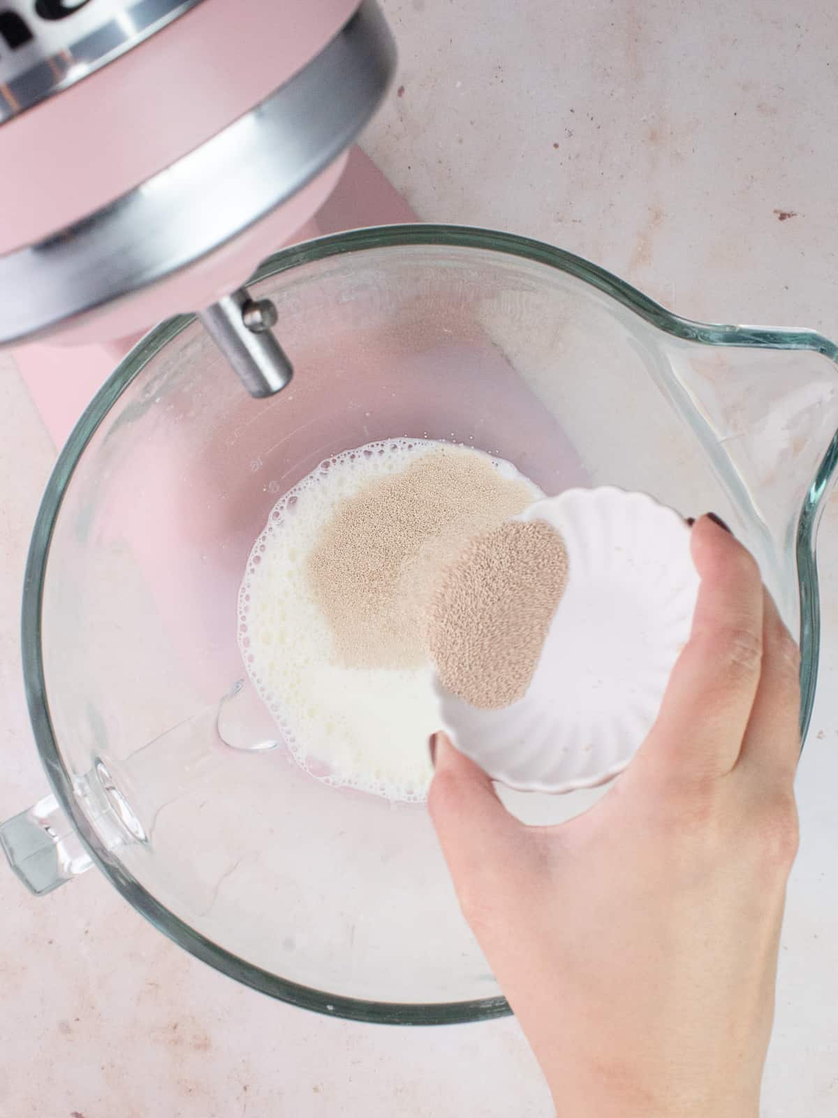 Pouring yeast into bowl of stand mixer