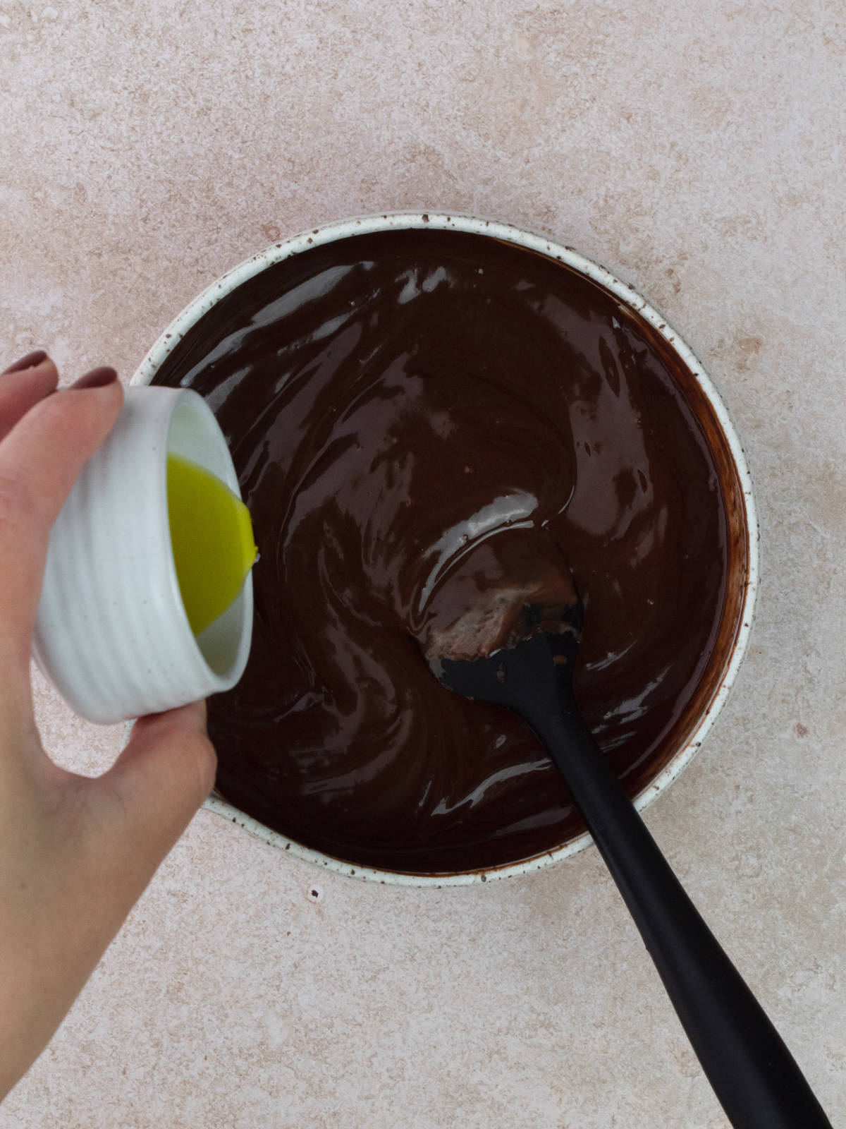 Pouring olive oil into ganache