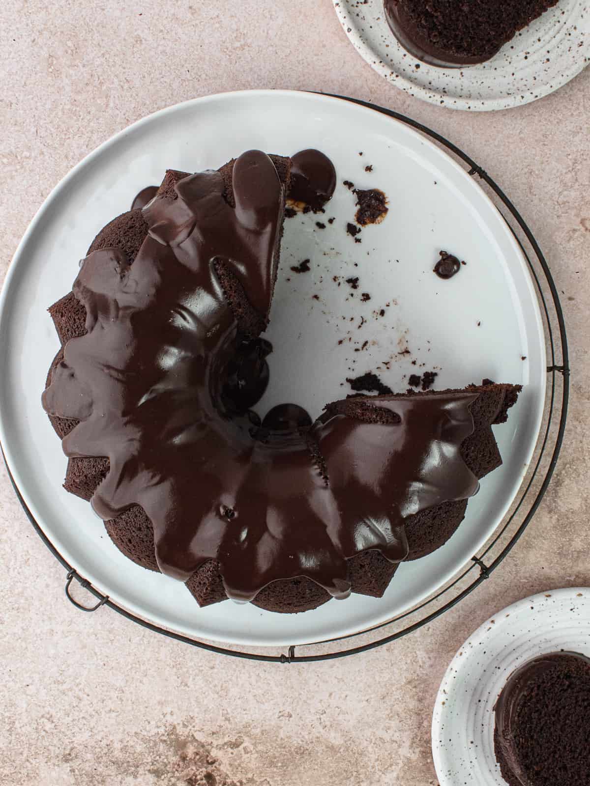 Chocolate olive oil bundt cake with chocolate ganache and plates of cake