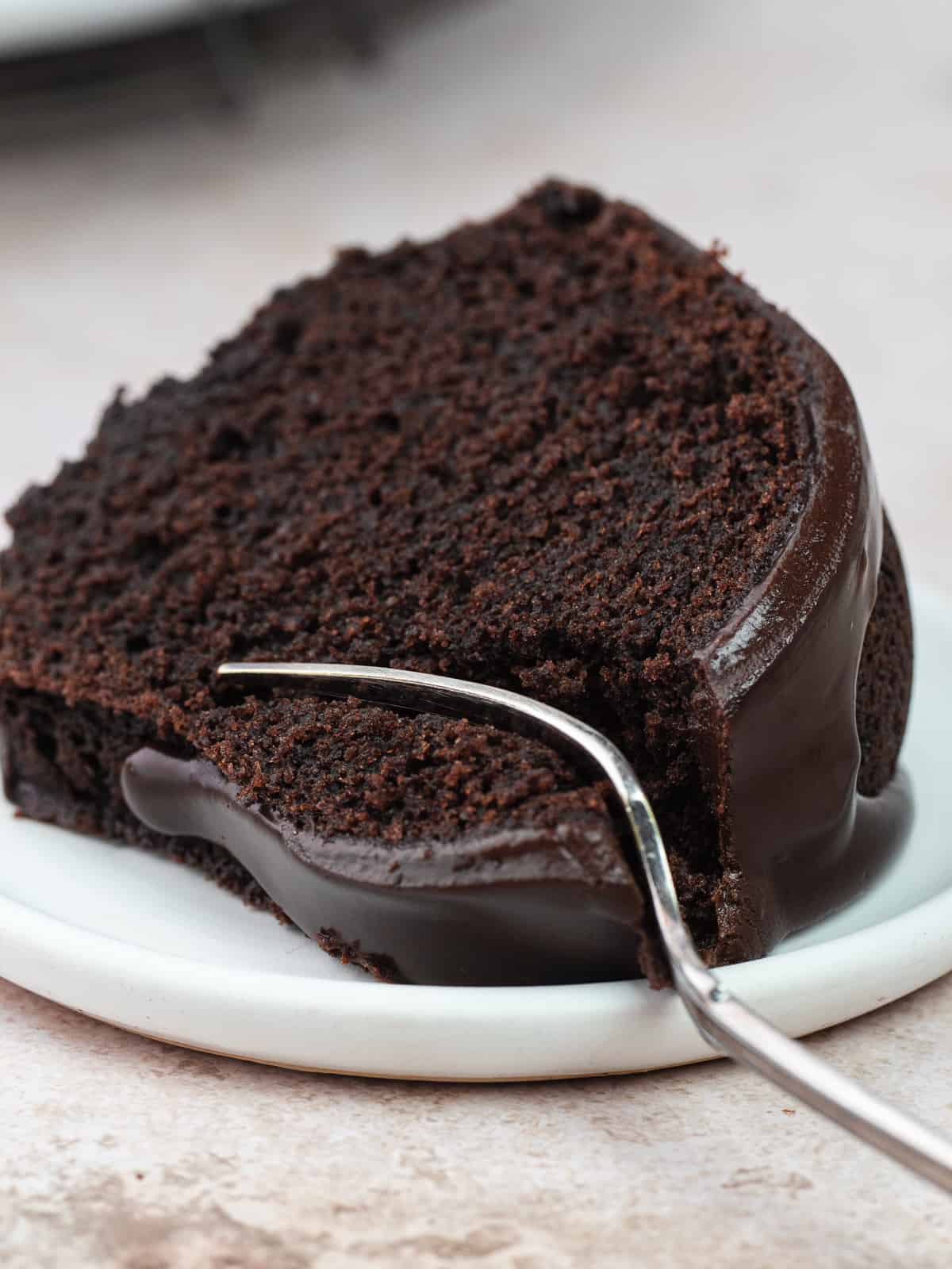 Chocolate olive oil bundt cake slice on plate with fork