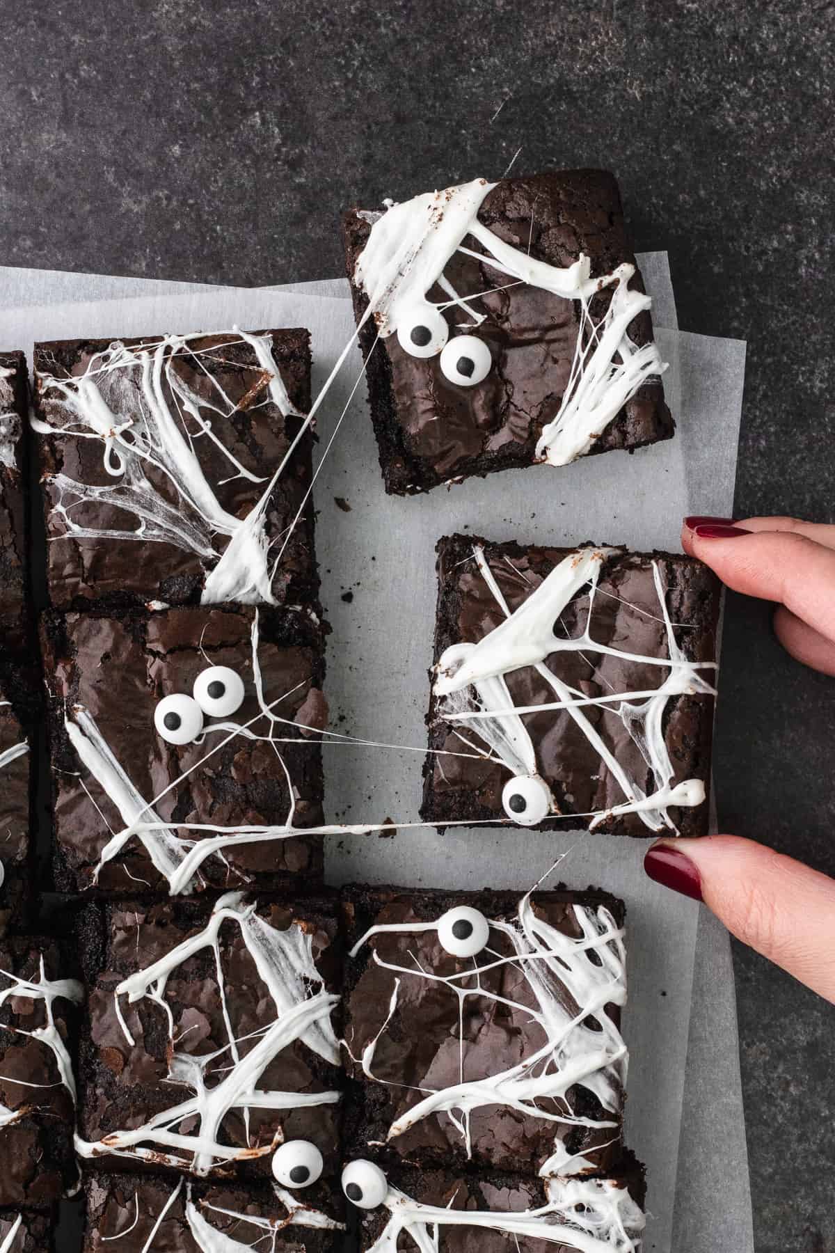 Hand reaches for spider web olive oil brownies