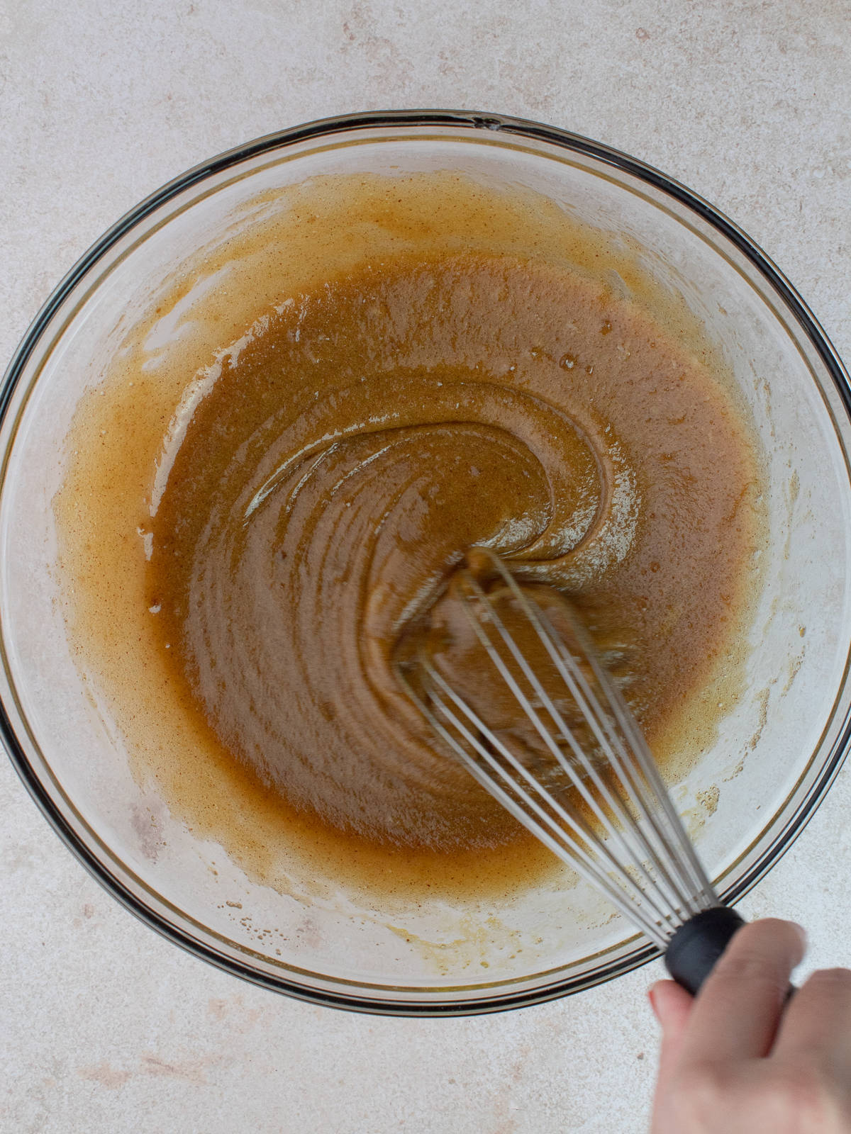 Brown butter, brown sugar, egg, yolk and vanilla are in a large glass mixing bowl are whisked together