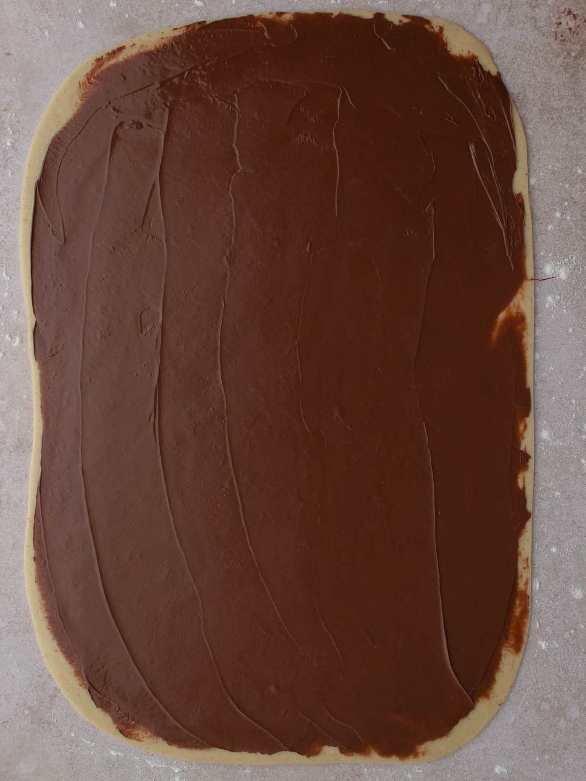 Dough rolled out to a rectangle with a layer of Nutella on top