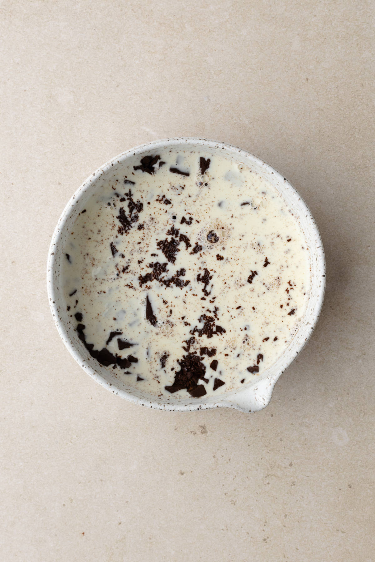 Finely chopped chocolate submerged in hot cream