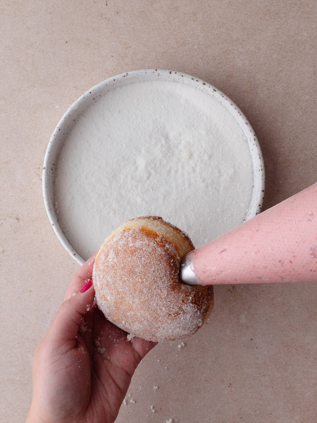 Filling sugared donut with filling