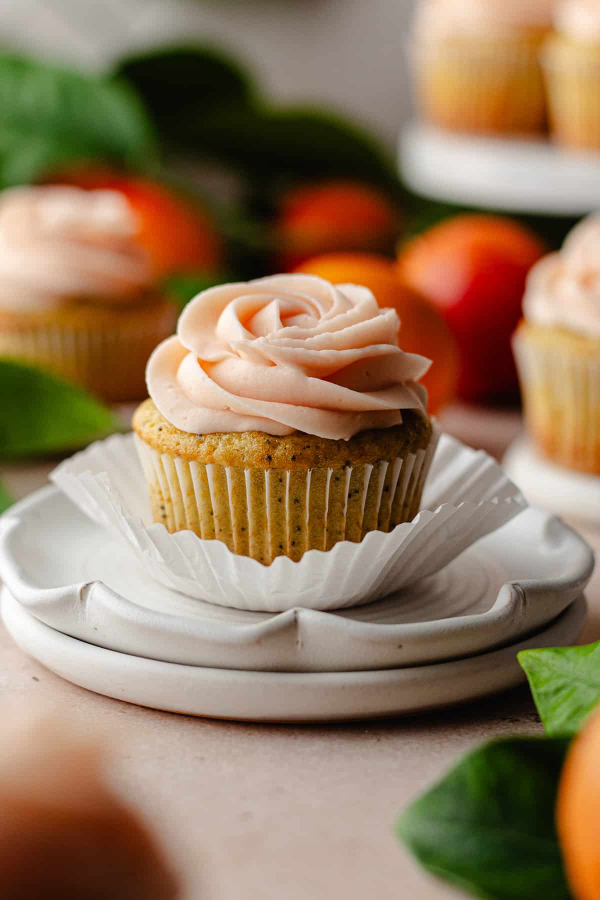 Orange poppy seed cupcake on a stack of plates