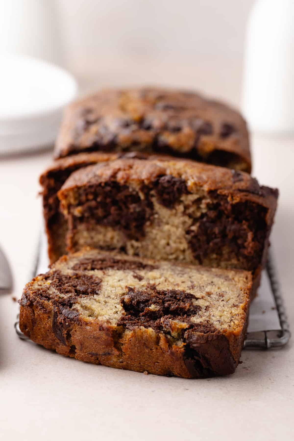 Chocolate marbled banana bread sliced on wire rack.