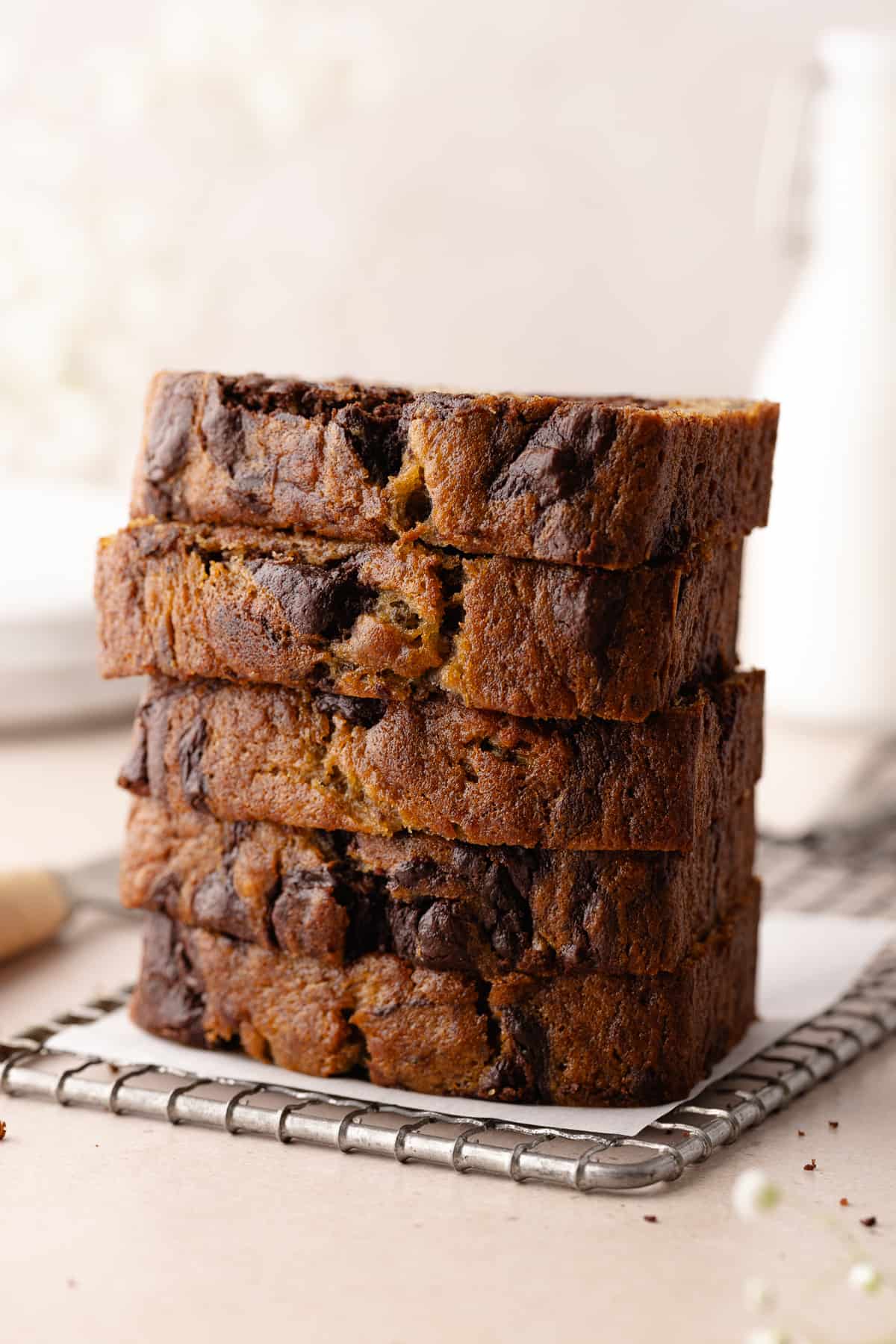 Chocolate marbled banana bread sliced and stacked on wire rack.