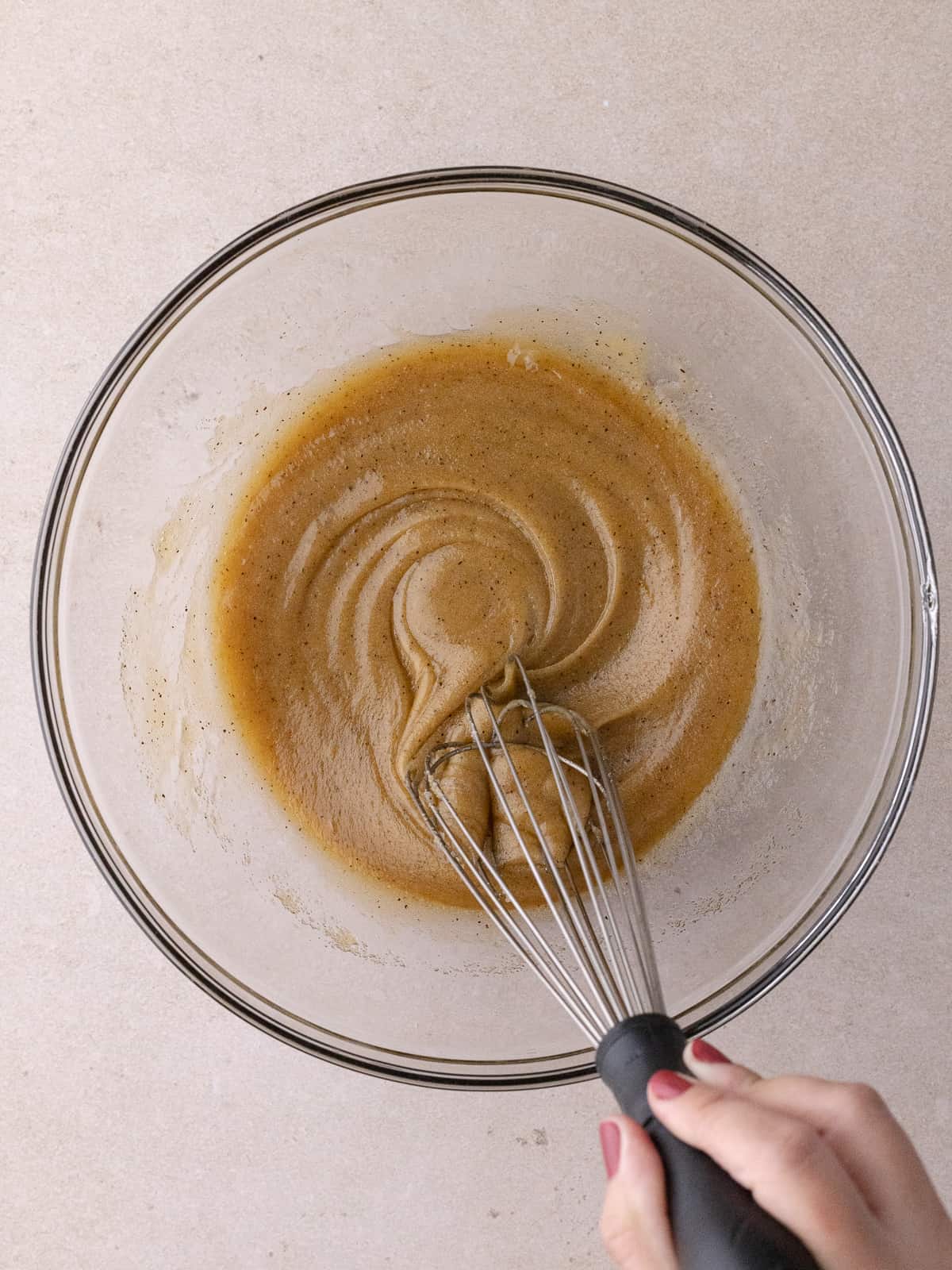 Whisking an egg into the butter sugar mixture.