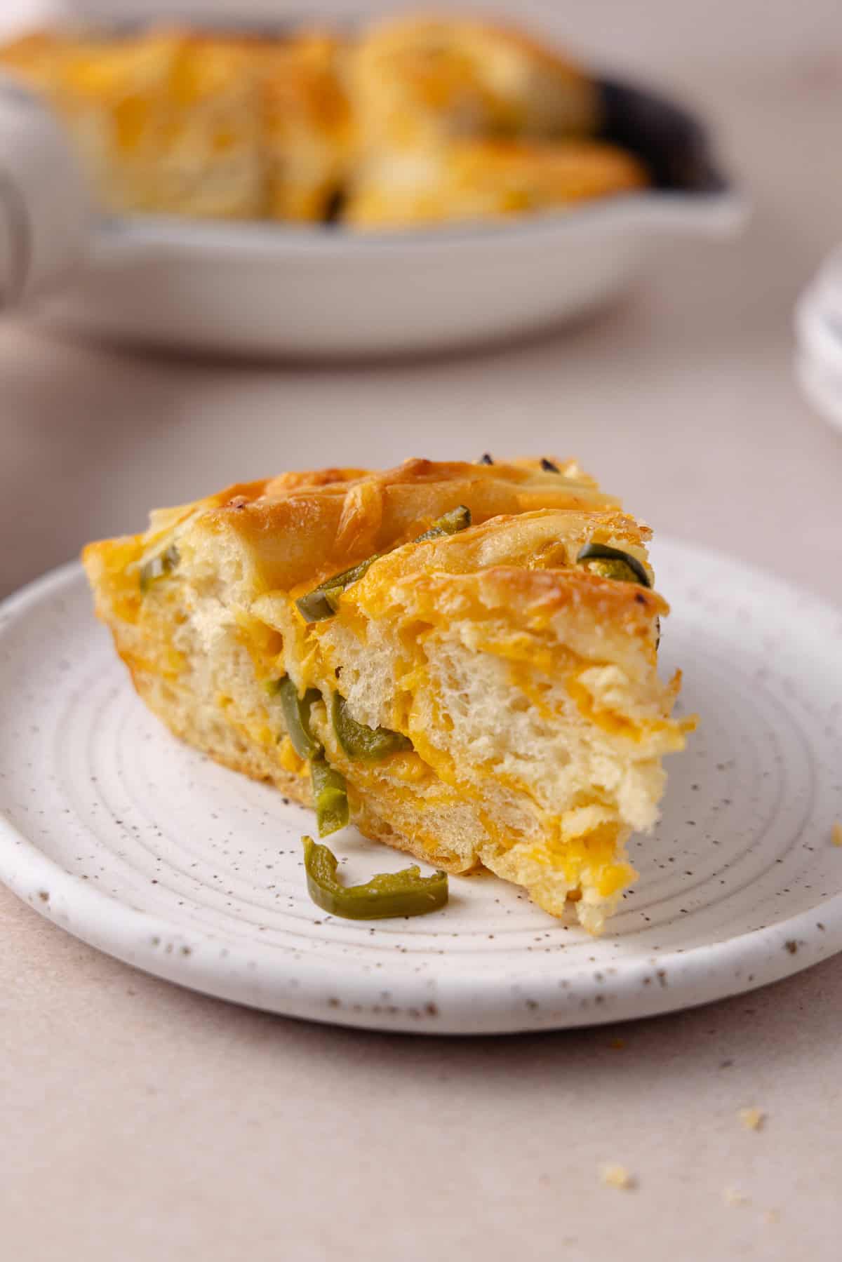 A piece on Jalapeno cheddar twist bread on a small plate.