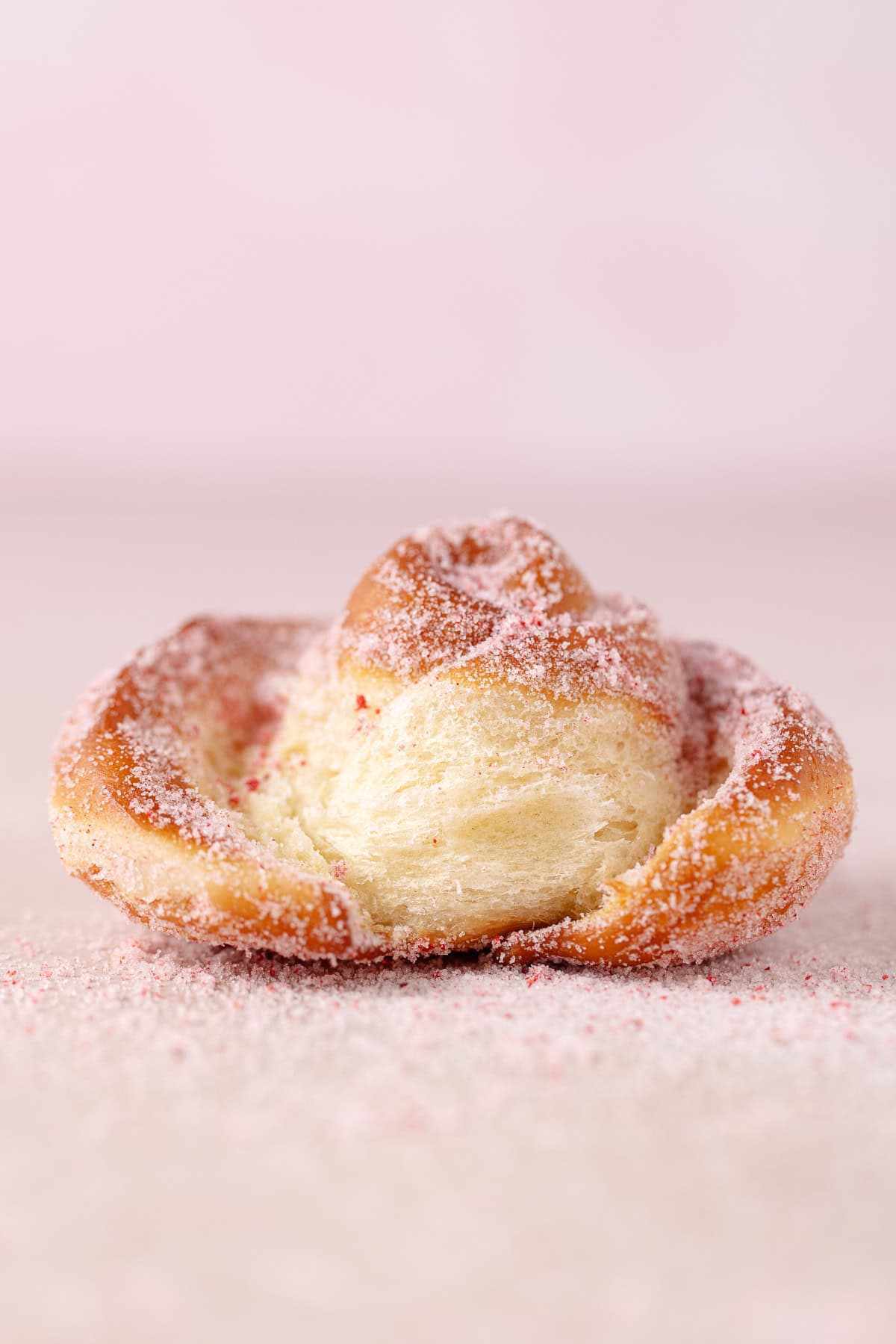 Close up of a rose donut, showing fluffy texture.