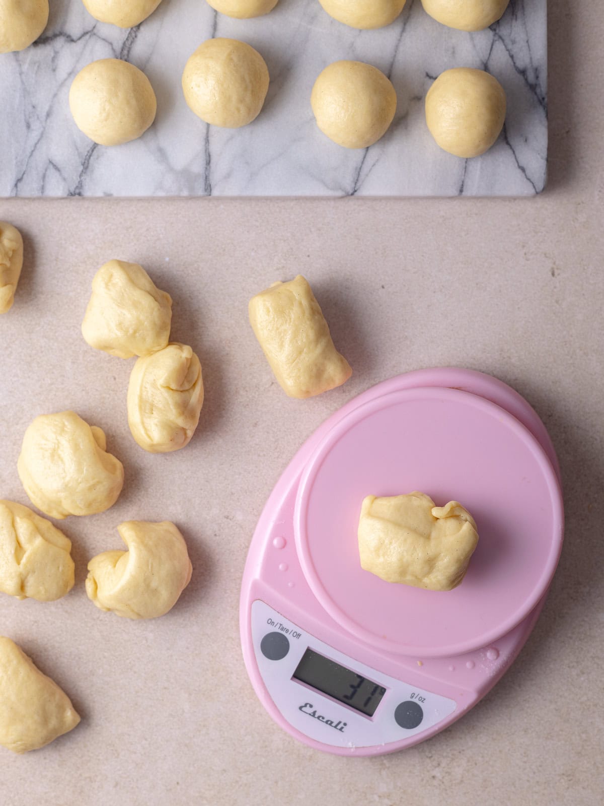 Dough balls are divided evenly using a kitchen scale.