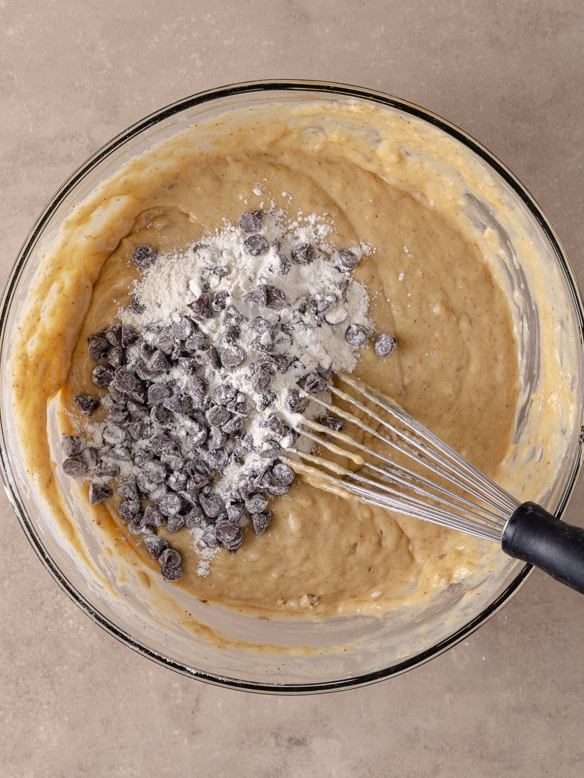 Flour coated chocolate chips are added to the batter and is ready to be incorporated.