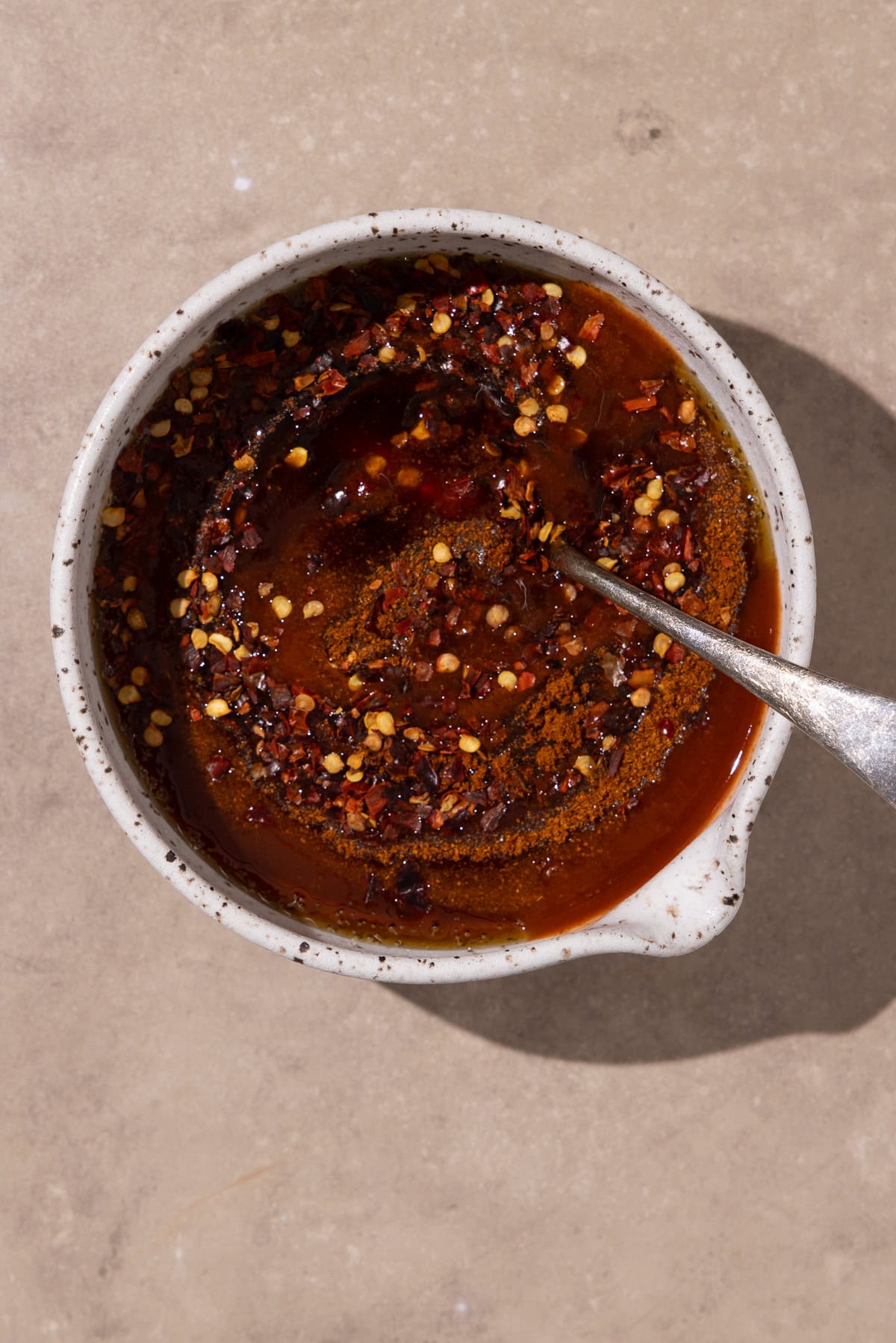 Hot honey ingredients mixed together in a small bowl with a spoon.
