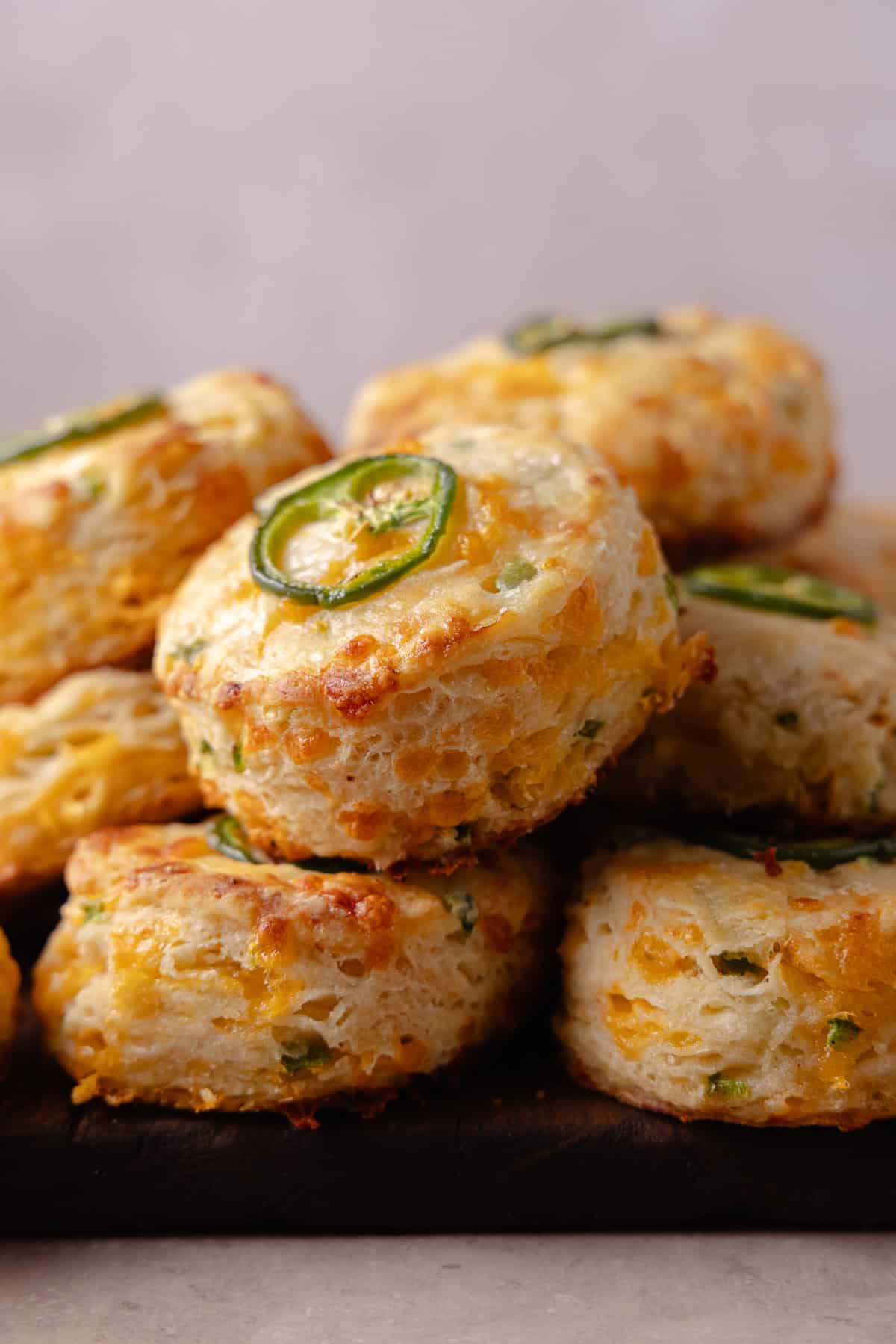 A pile of Jalapeno Cheddar Biscuits on a cutting board.
