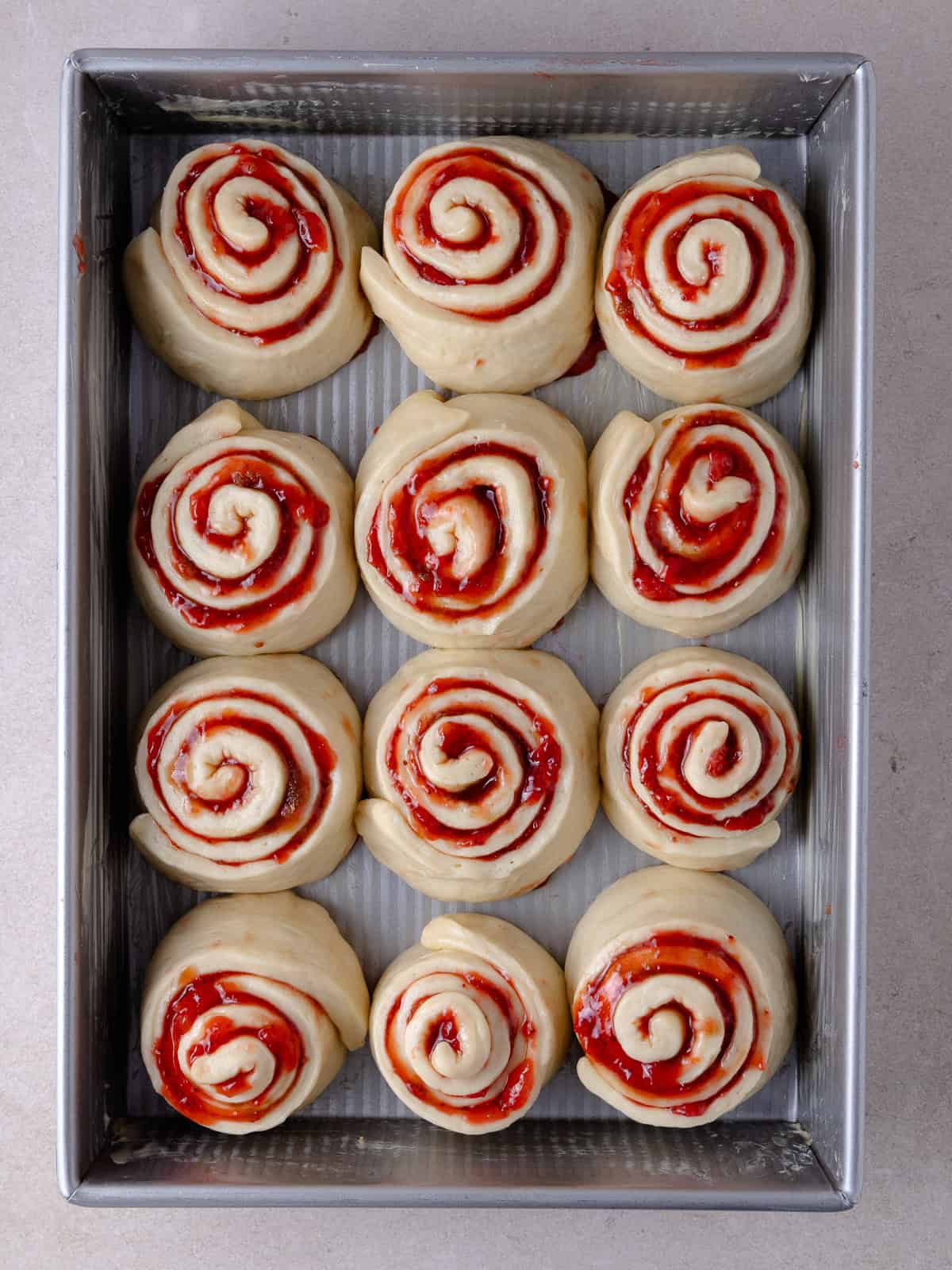 Strawberry rolls are placed in large buttered baking tray. Rolls will need to proof for about 30 to 45 minutes.