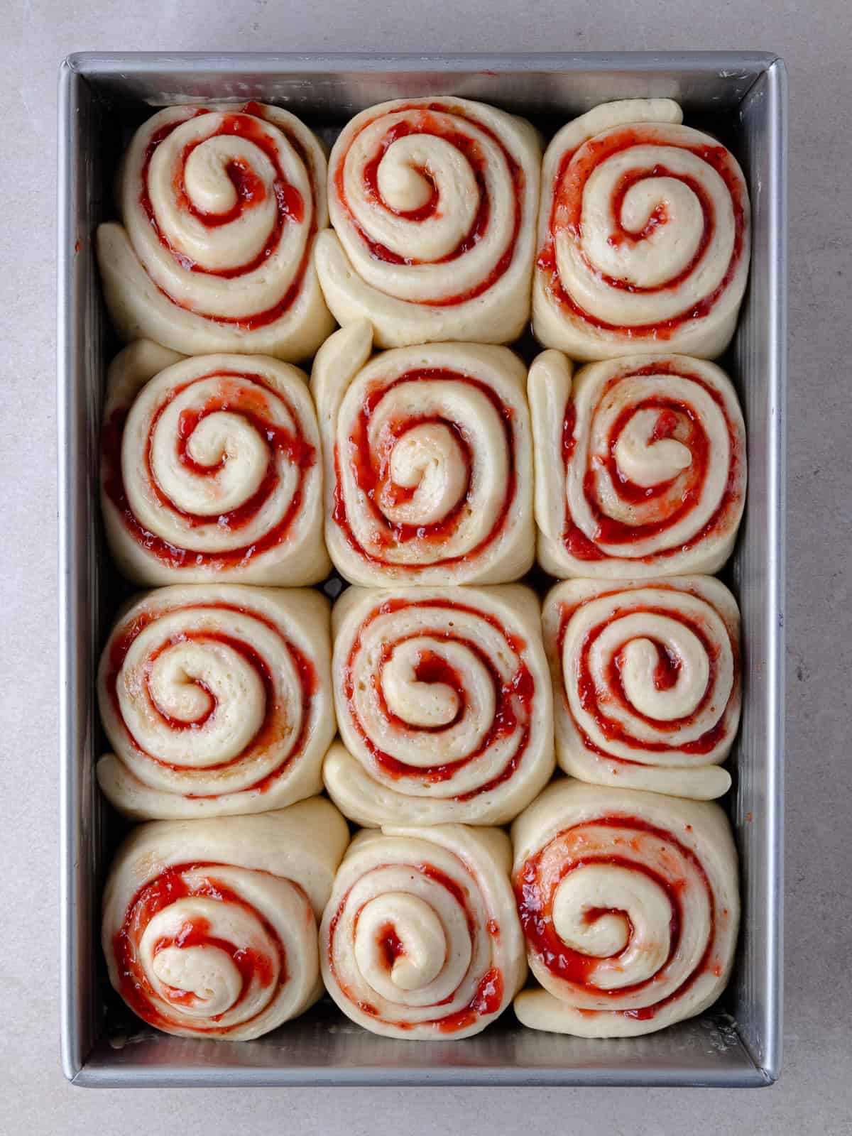 Strawberries cinnamon rolls after it has finished proofing and is ready to be baked in the oven.