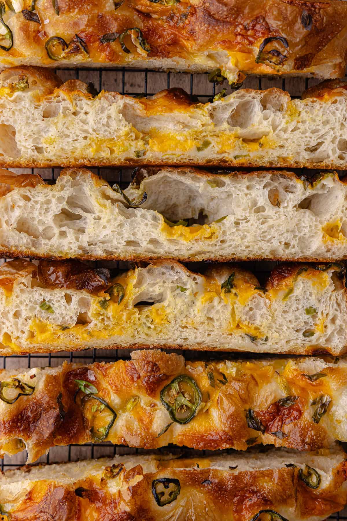 Strips of Jalapeño cheddar focaccia on a black cooling rack.