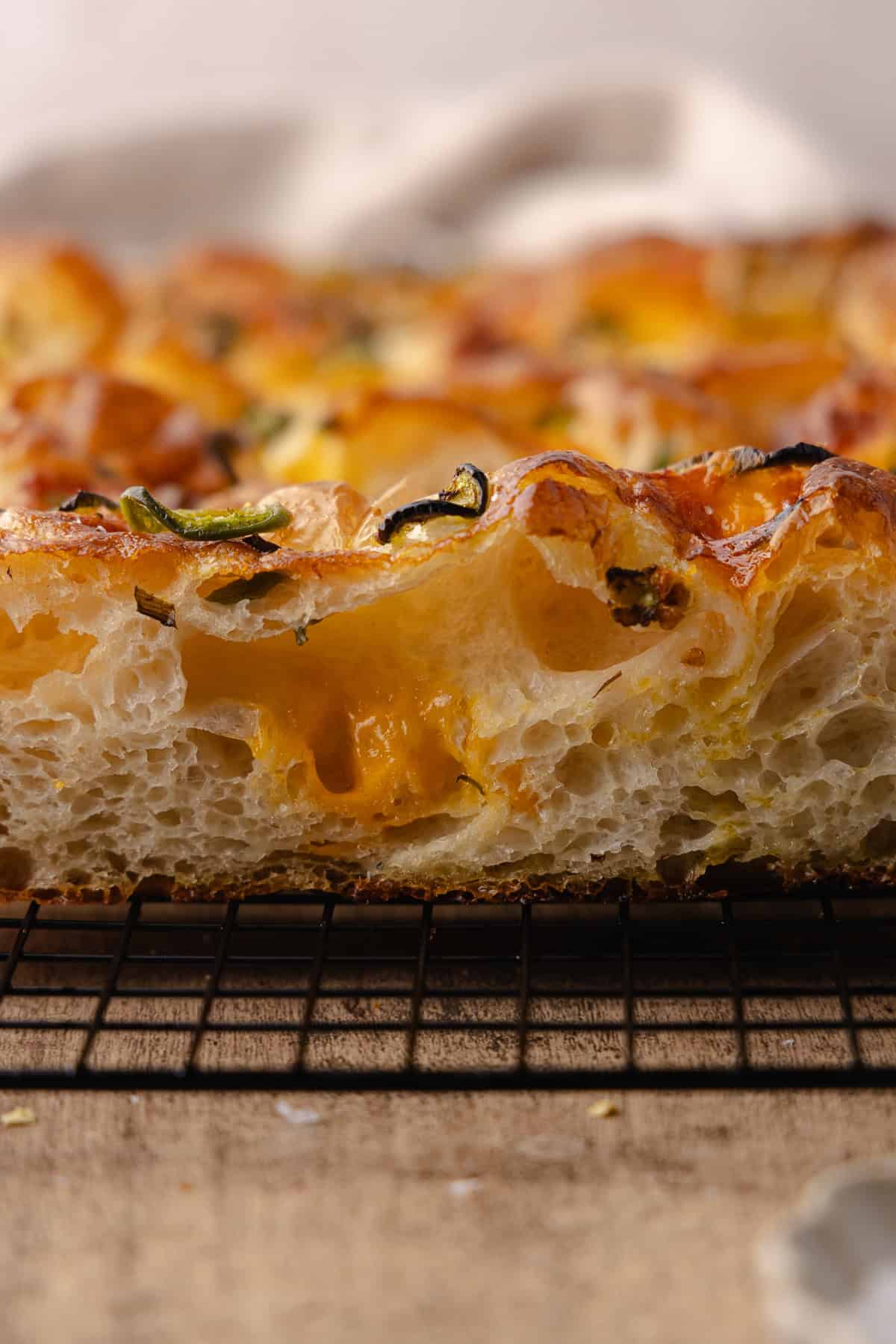Side view of the Jalapeño cheddar focaccia on a black cooling rack.