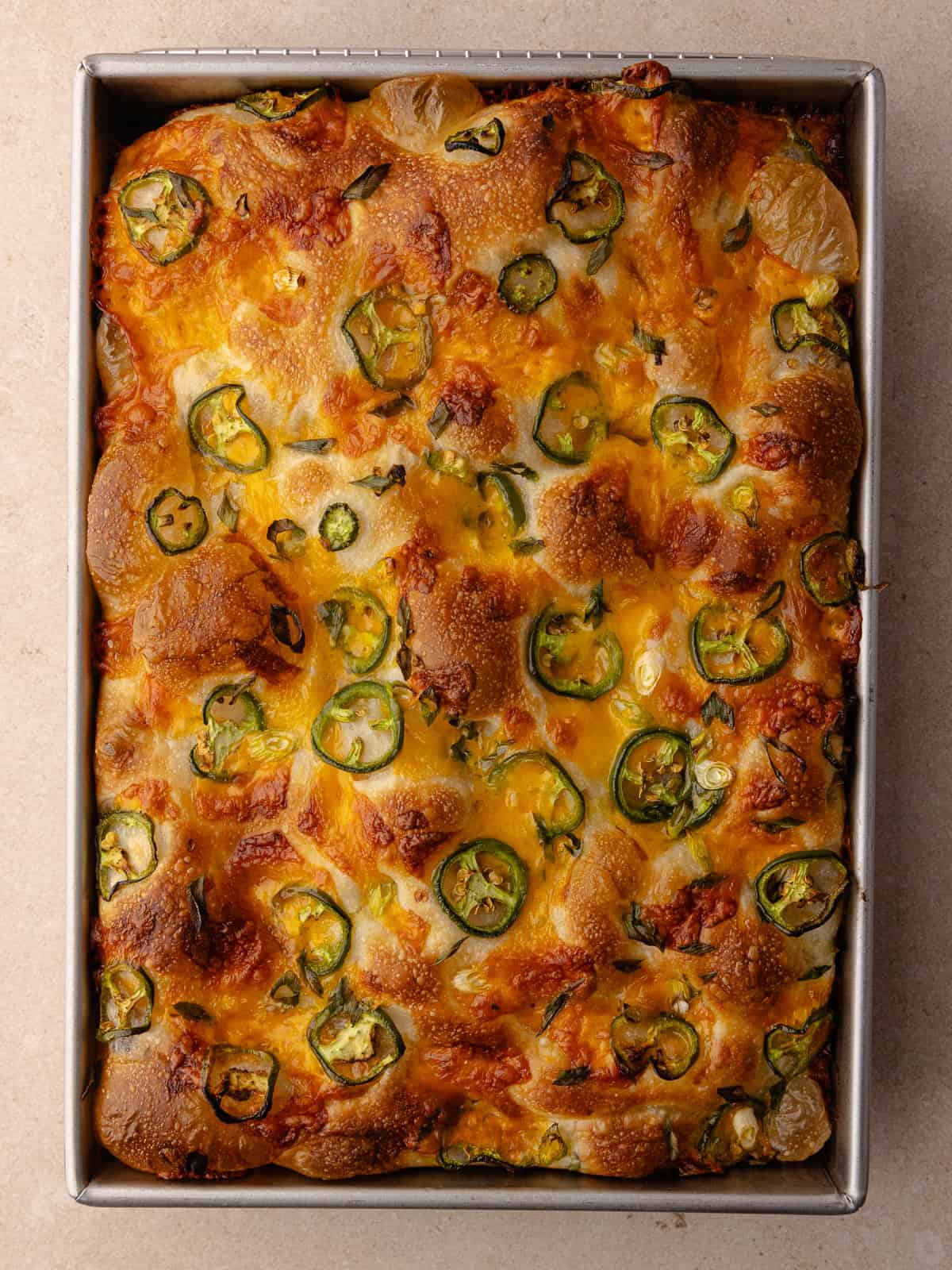 Baked Jalapeño cheddar focaccia sitting in a baking pan.