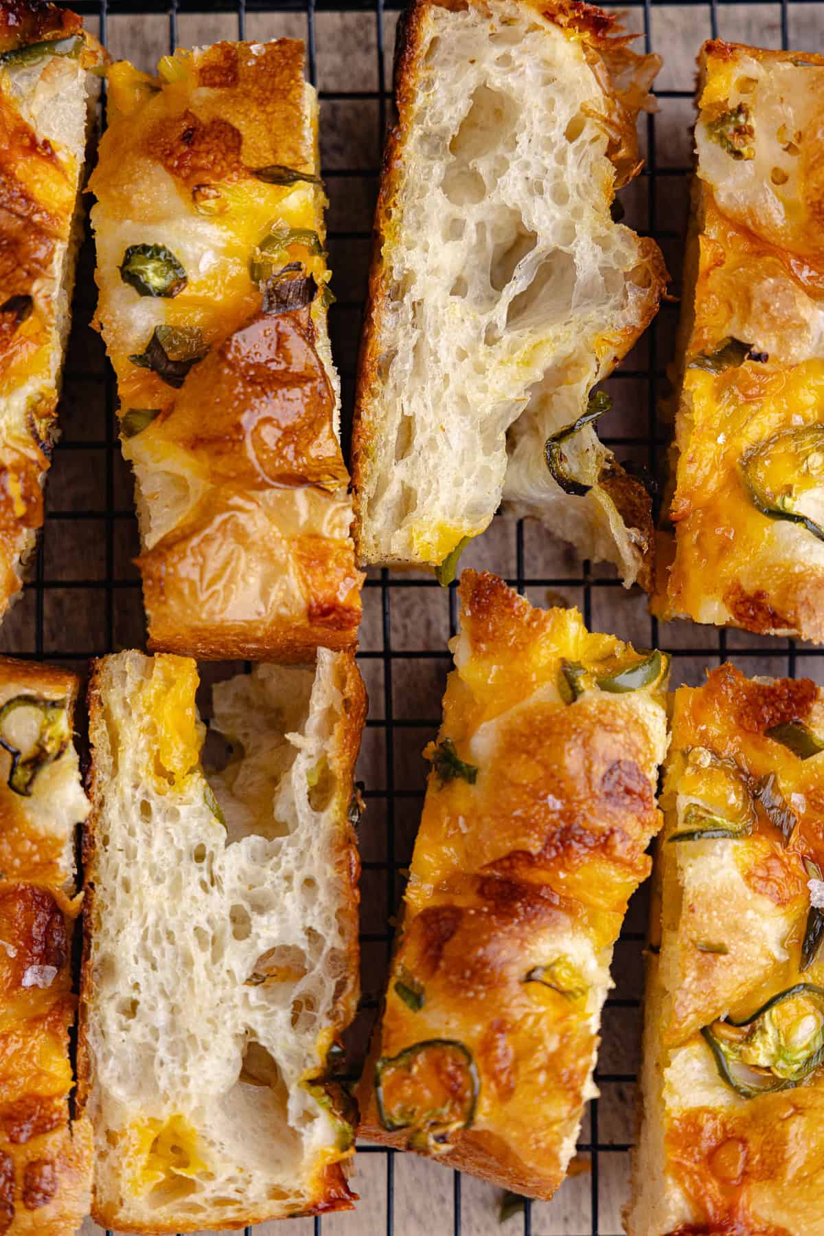 Sliced jalapeño cheddar focaccia sitting on a wire rack.