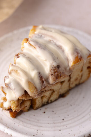 Giant cinnamon rolls cake slice sitting on a dessert plate, feature photo.