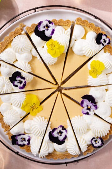 Easy lemon condensed milk tart with graham cracker crust, cut into slices and sitting on a serving plate feature photo.