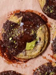 Pistachio chocolate chip cookies stuffed with pistachio cream and topped with flaky sea salt featured photo.