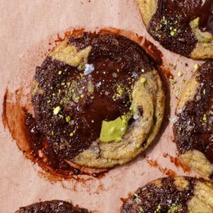 Pistachio chocolate chip cookies stuffed with pistachio cream and topped with flaky sea salt featured photo.