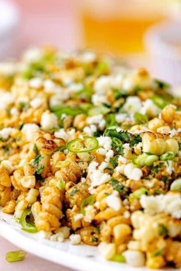Elote pasta salad with charred corn, gemelli pasta, crumbled cotija cheese, chopped scallions, cilantro and chopped jalapeño tossed with creamy smokey Greek yogurt dressing feature photo.