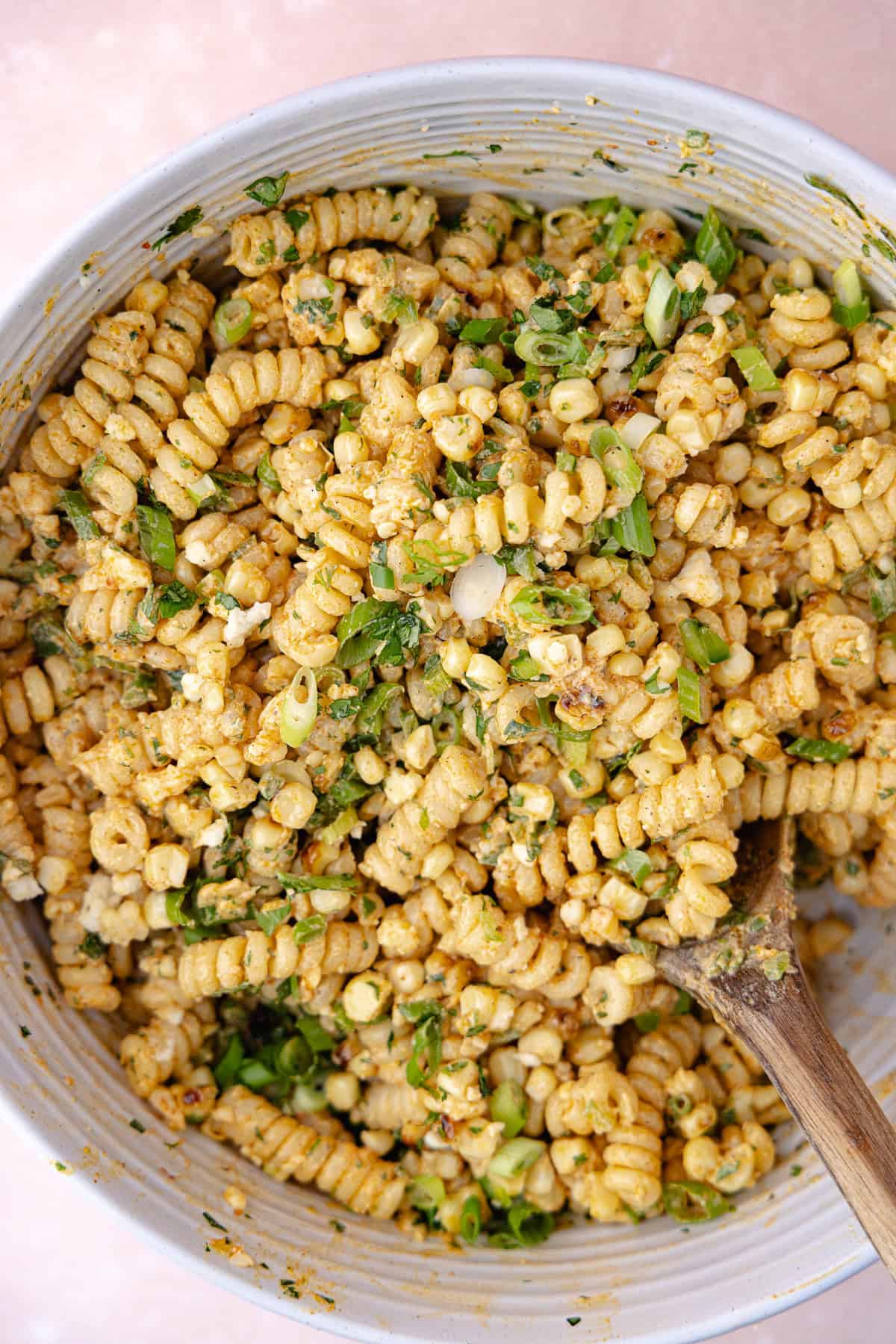 Elote pasta salad with charred corn, gemelli pasta, crumbled cotija cheese, chopped scallions, cilantro and chopped jalapeño tossed with creamy smoky Greek yogurt dressing.