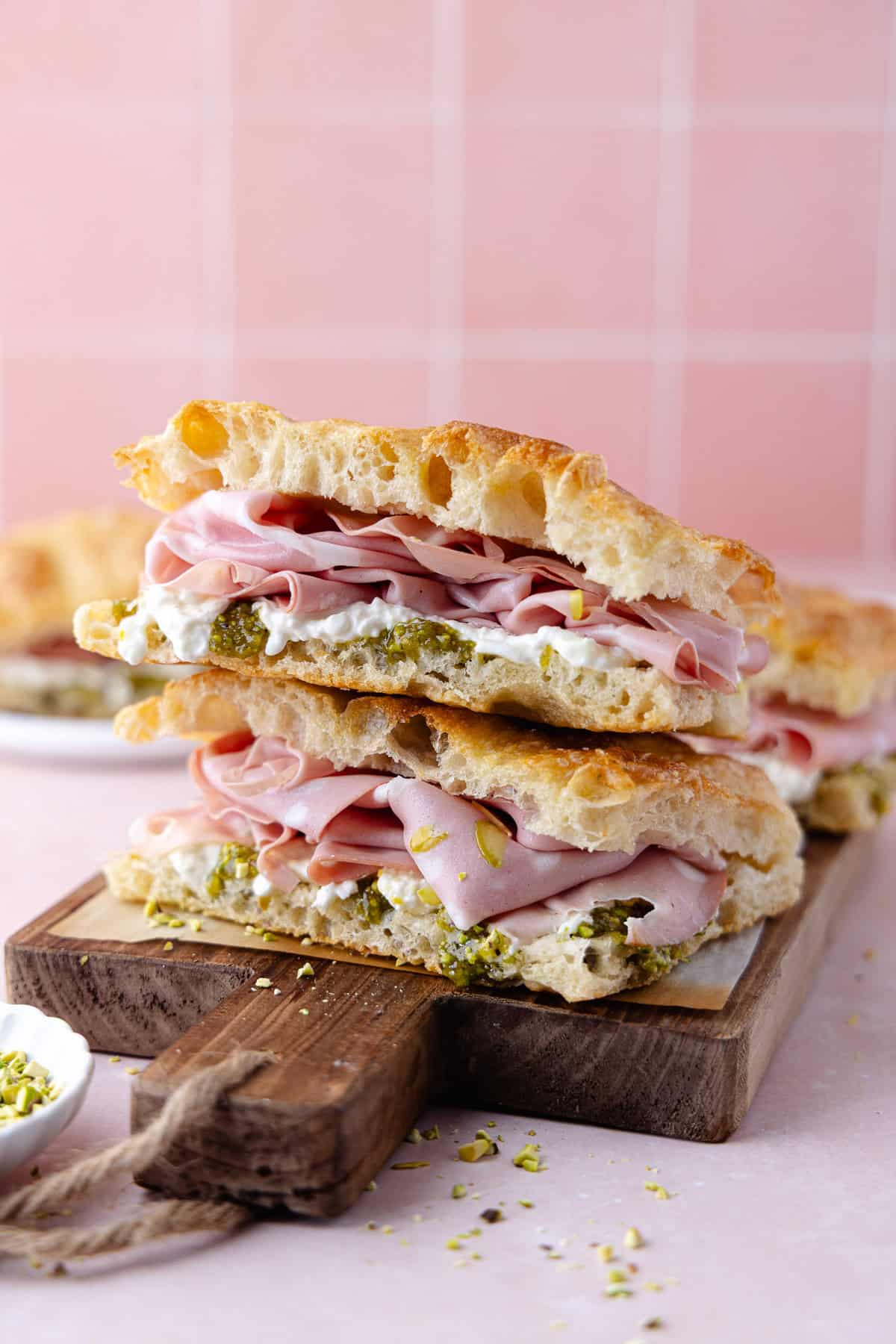 Pistachio mortadella sandwich with pistachio spread and stracciatella cheese on homemade schiacciata bread.
