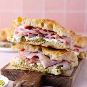 Pistachio mortadella sandwich with pistachio spread and stracciatella cheese on homemade schiacciata bread featured photo.