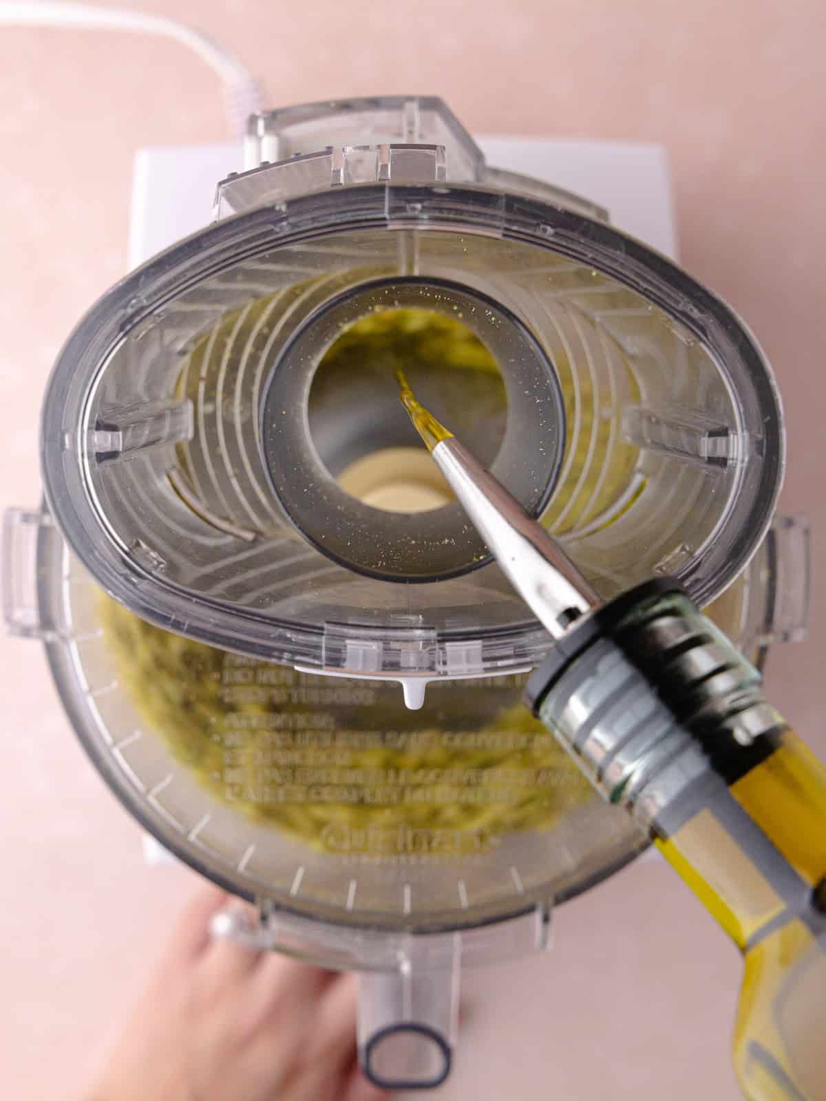 Olive oil is streamed into the food processor.