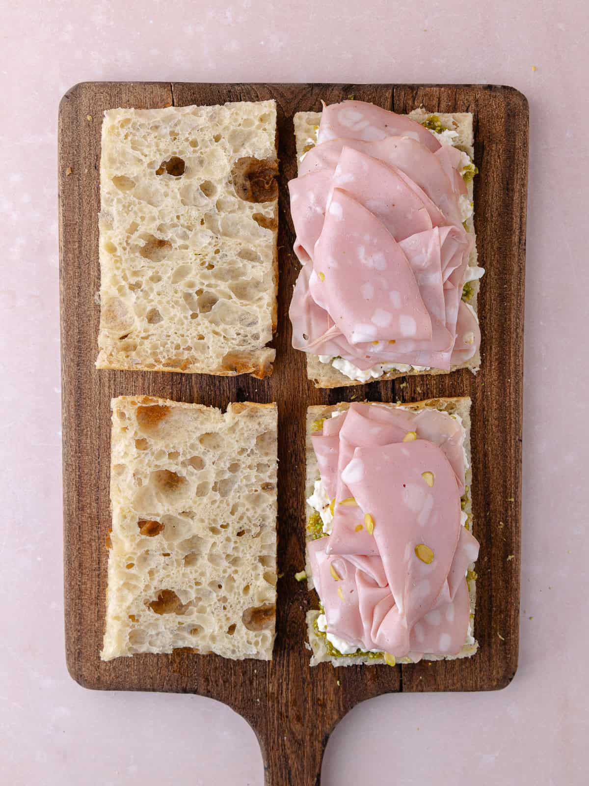 Pistachio mortadella is draped over the pistachio cream and stracciatella cheese.