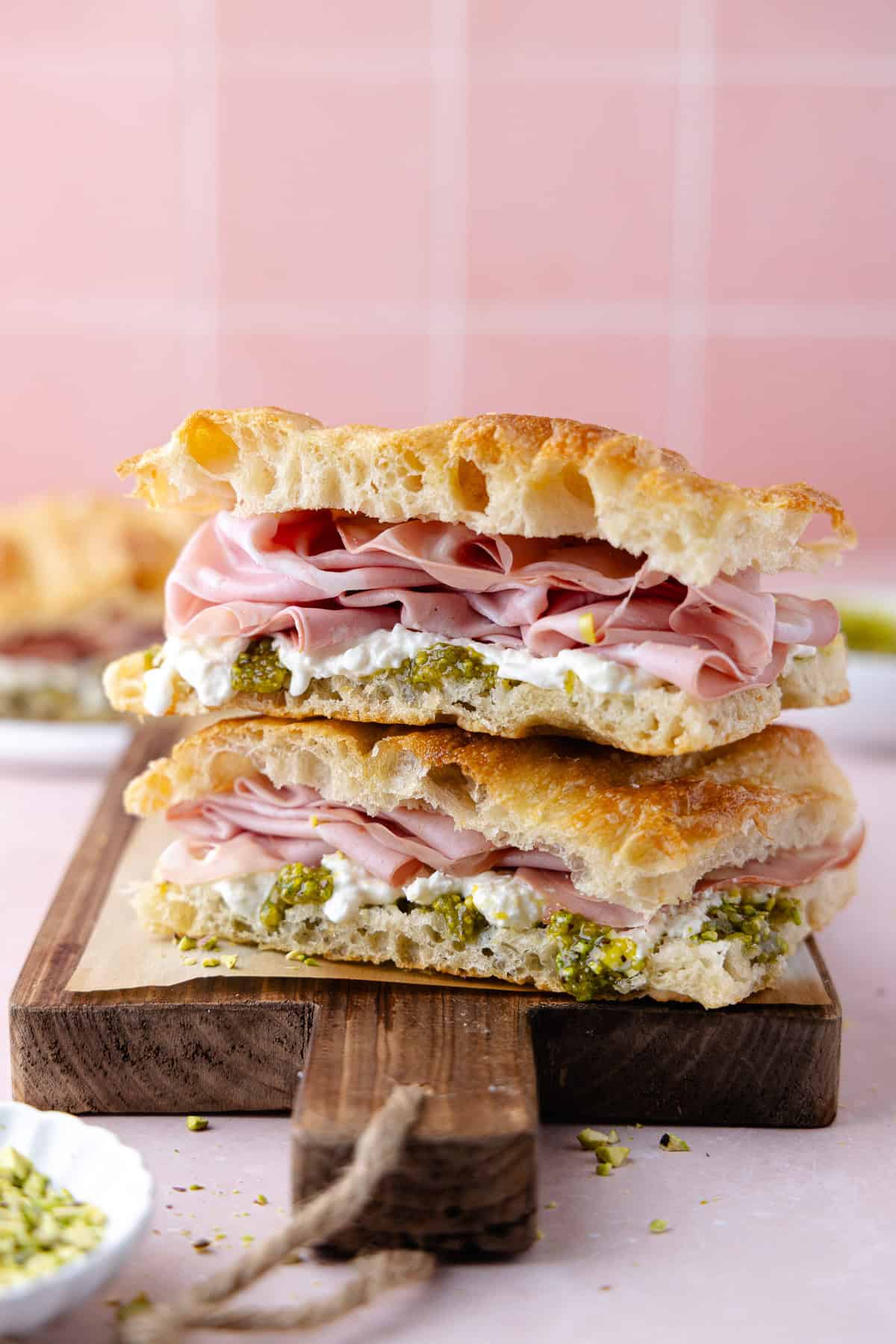 Pistachio mortadella sandwich with pistachio spread and stracciatella cheese on homemade schiacciata bread.