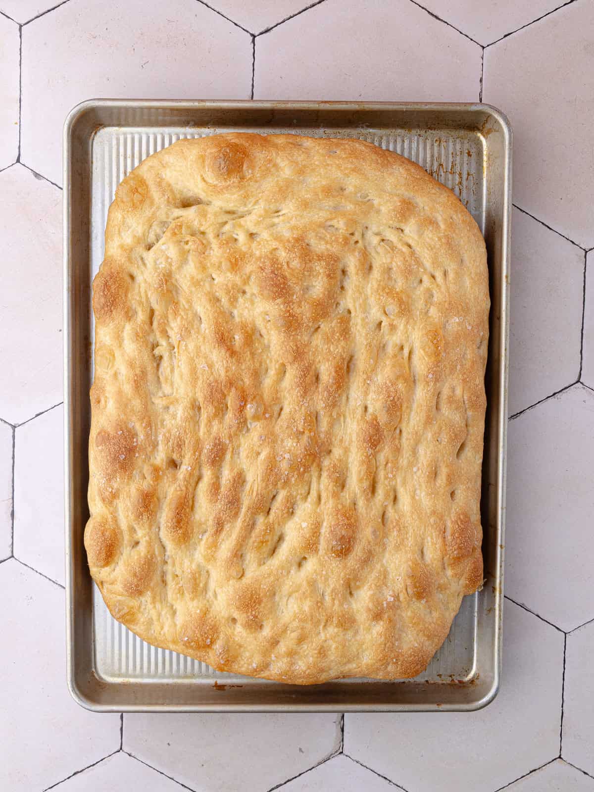 Schiacciata bread is baked until golden in a large cookie sheet.