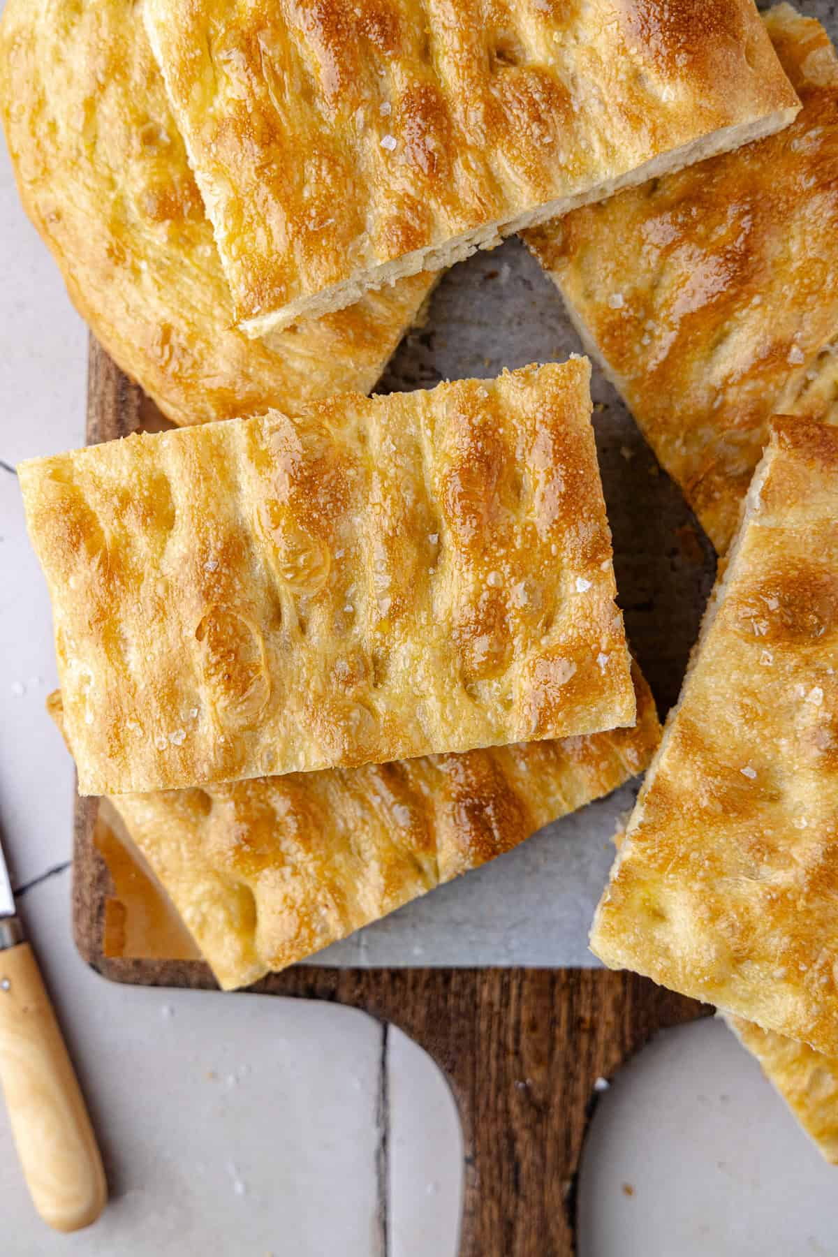 Schiacciata bread recipe sliced and sitting on a cutting board.